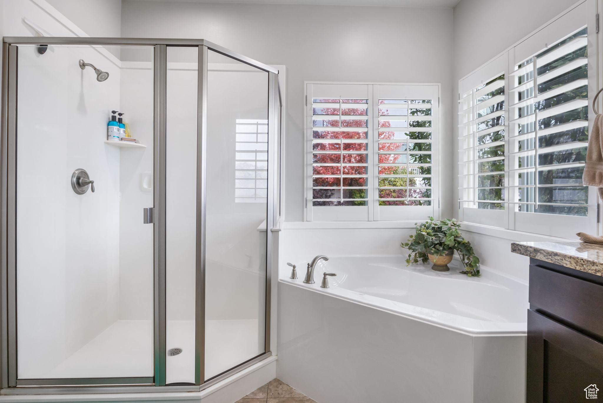 Bathroom featuring separate shower and tub, tile patterned flooring, and vanity