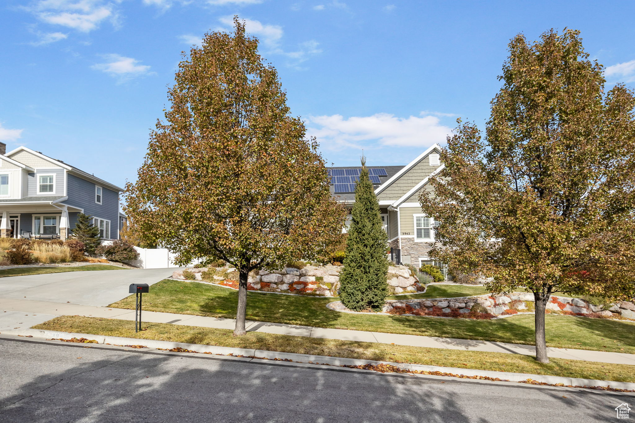 View of front of home with solar panels and a front lawn