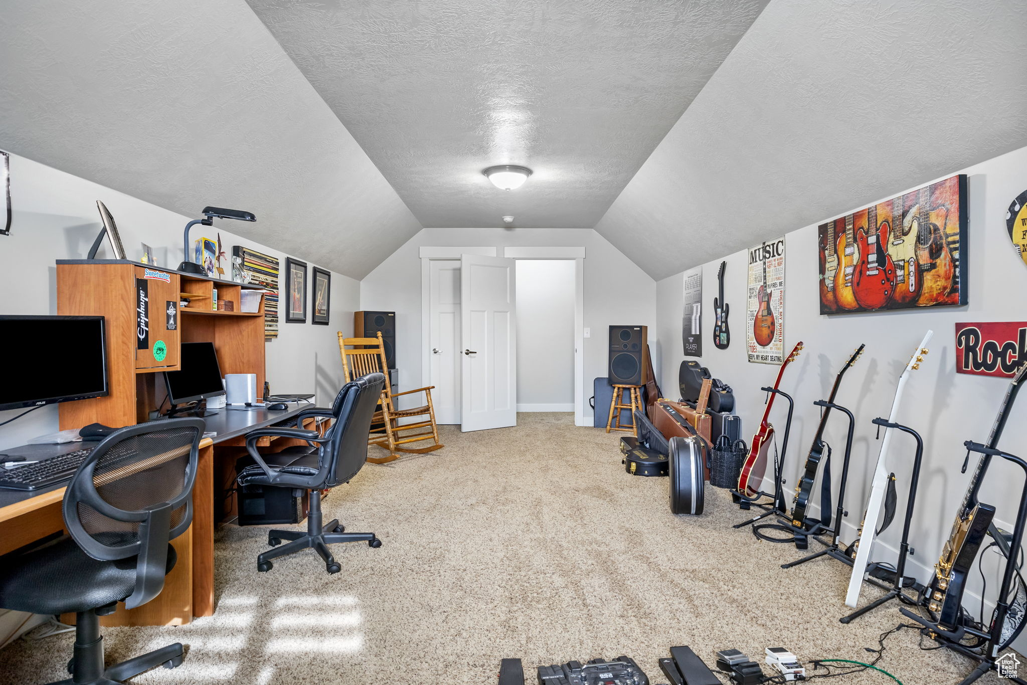 Office area with carpet, a textured ceiling, and lofted ceiling