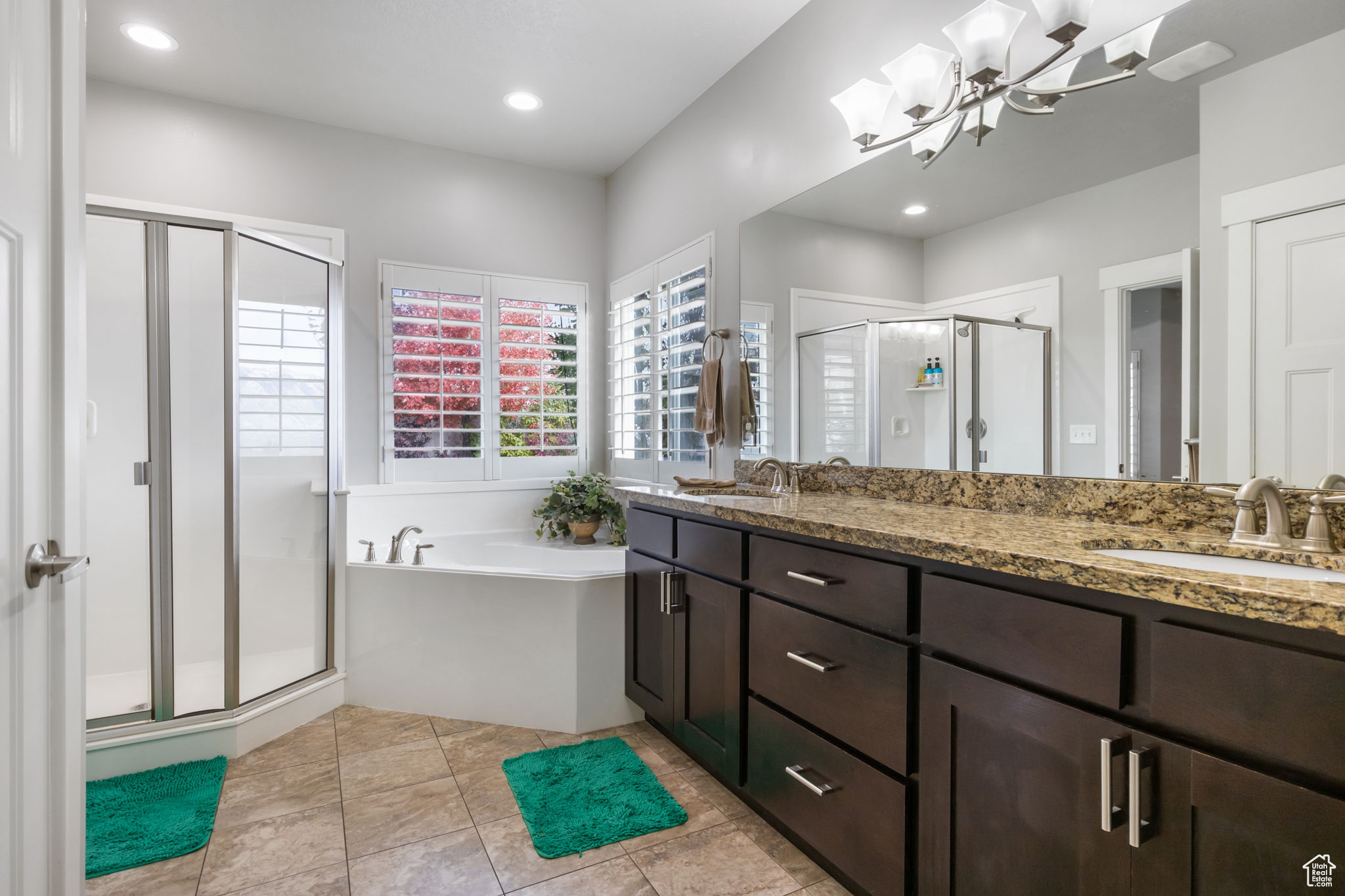 Bathroom featuring vanity, plus walk in shower, tile patterned flooring, and an inviting chandelier