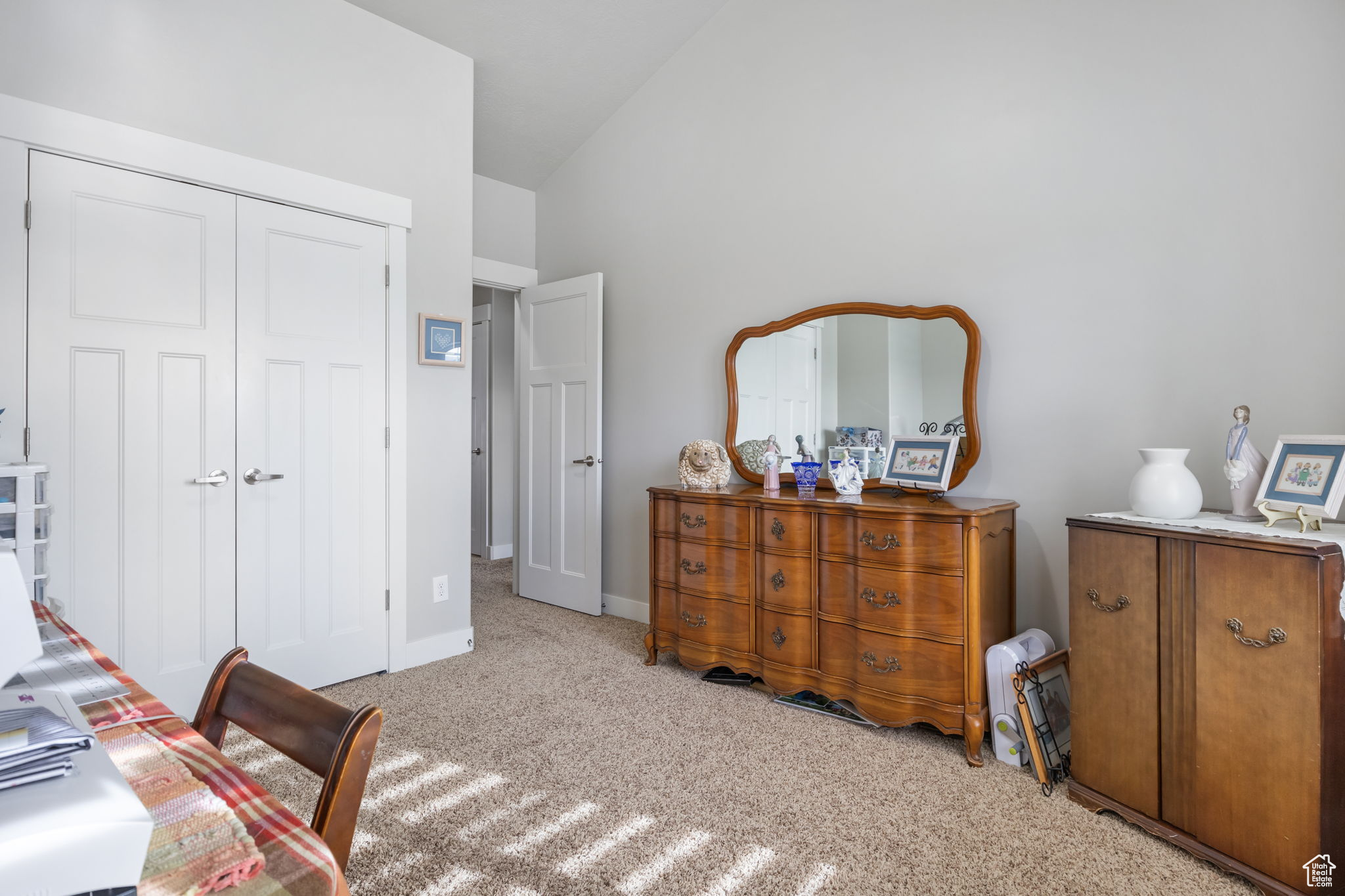 Bedroom featuring light carpet, a closet, and high vaulted ceiling