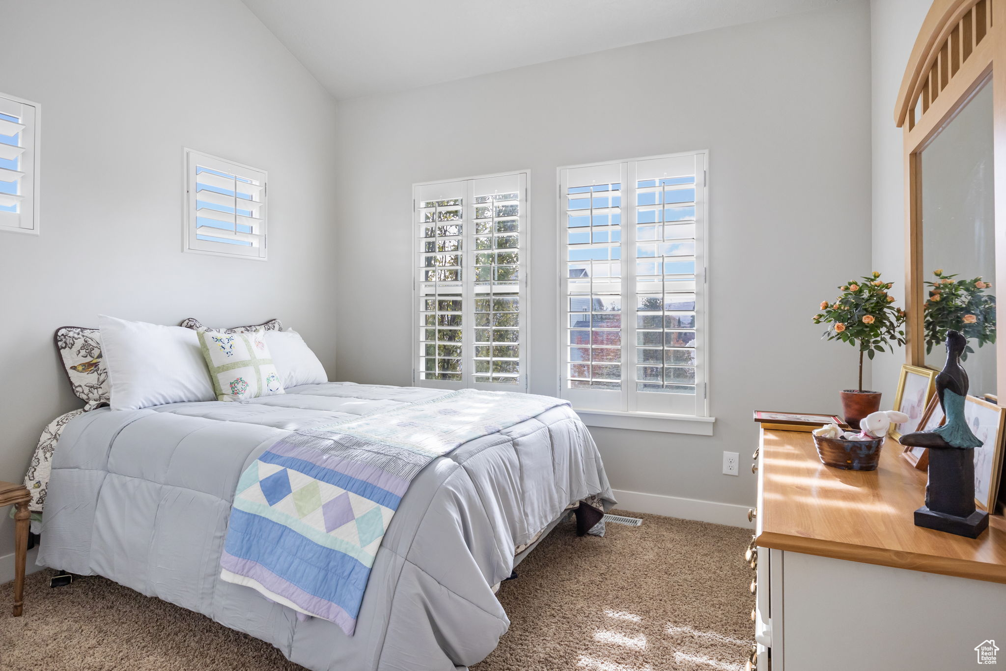 Bedroom with lofted ceiling and light colored carpet