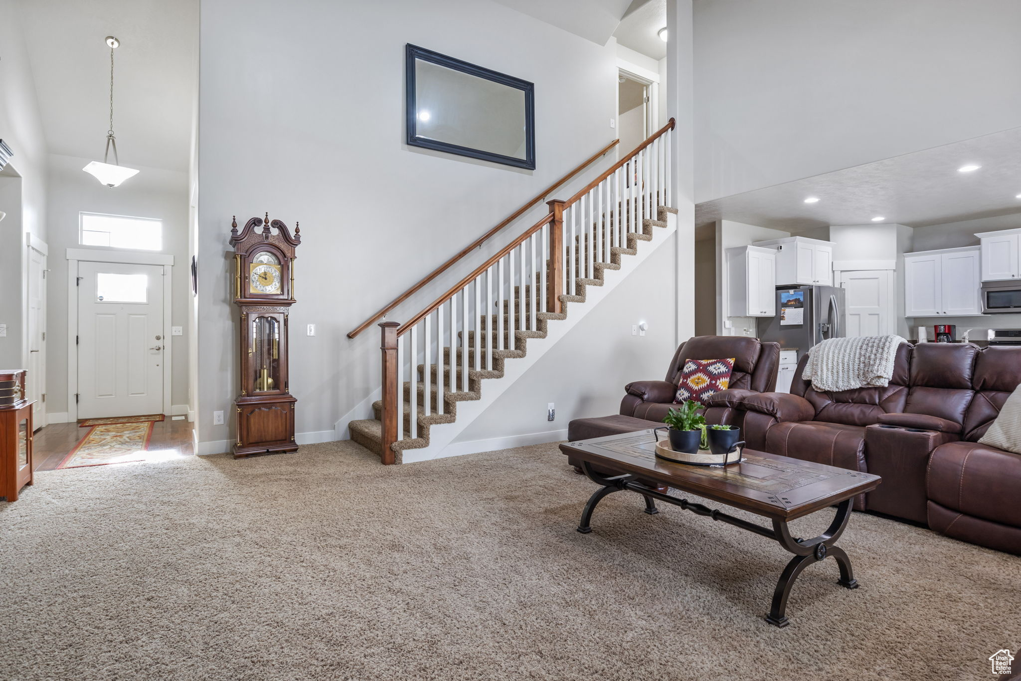 Carpeted living room featuring a high ceiling