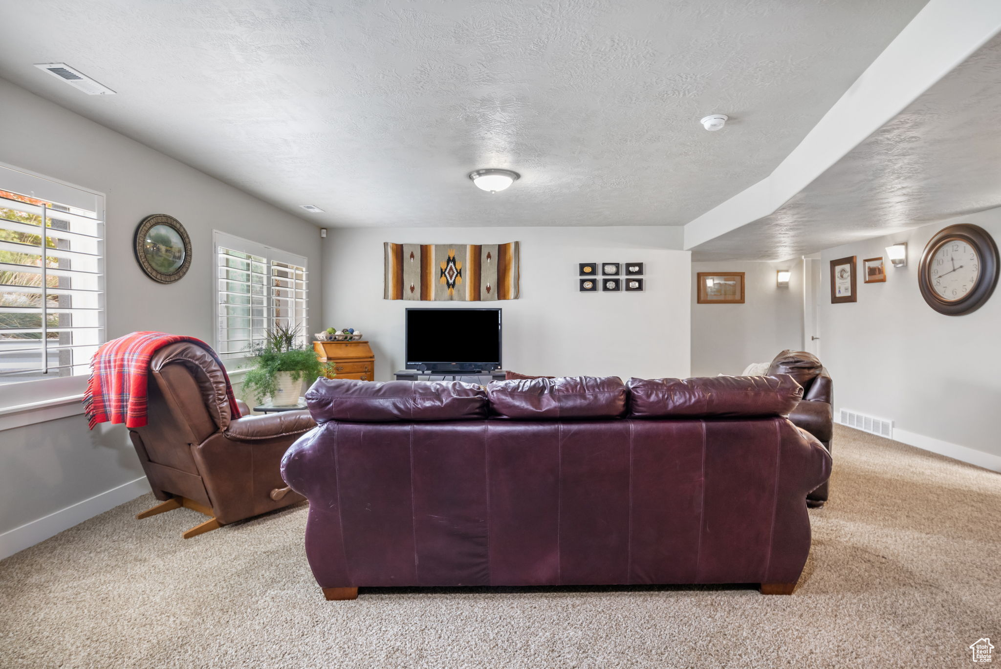 Living room with light colored carpet and a textured ceiling