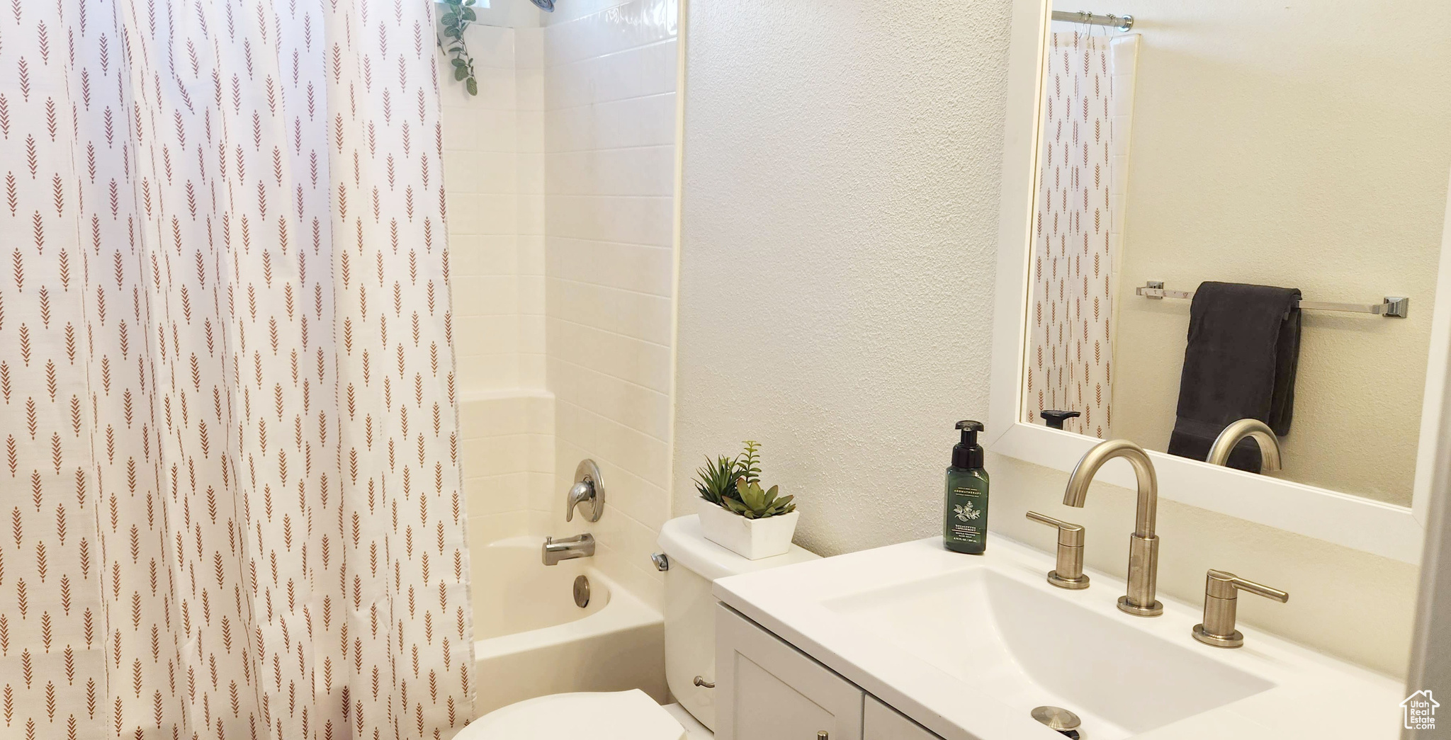 Full bathroom with bathtub / shower combination, vanity, and toilet