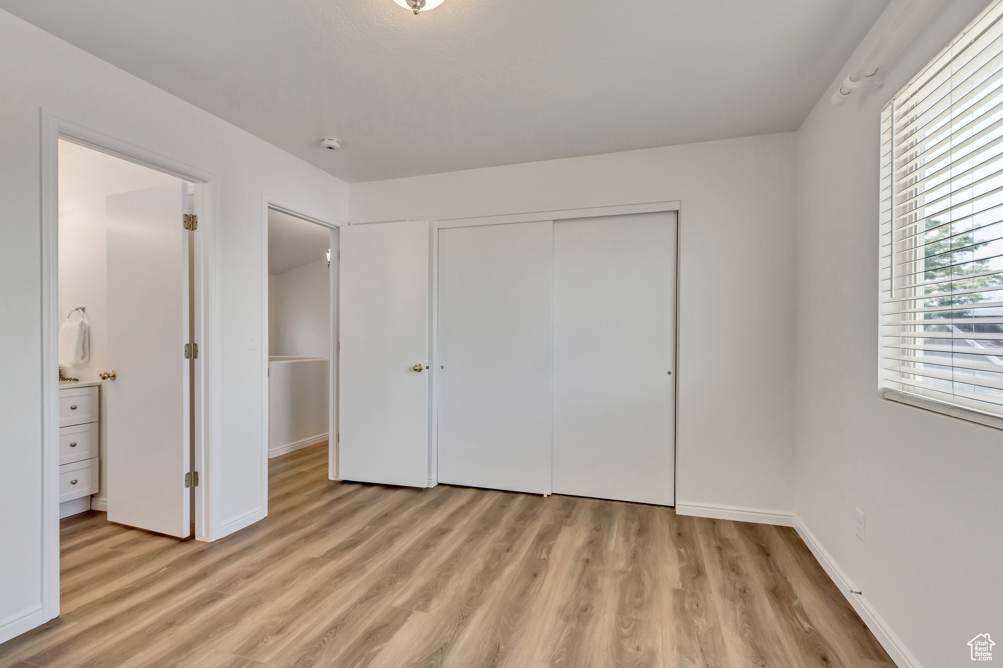 Unfurnished bedroom with light hardwood / wood-style flooring and a closet