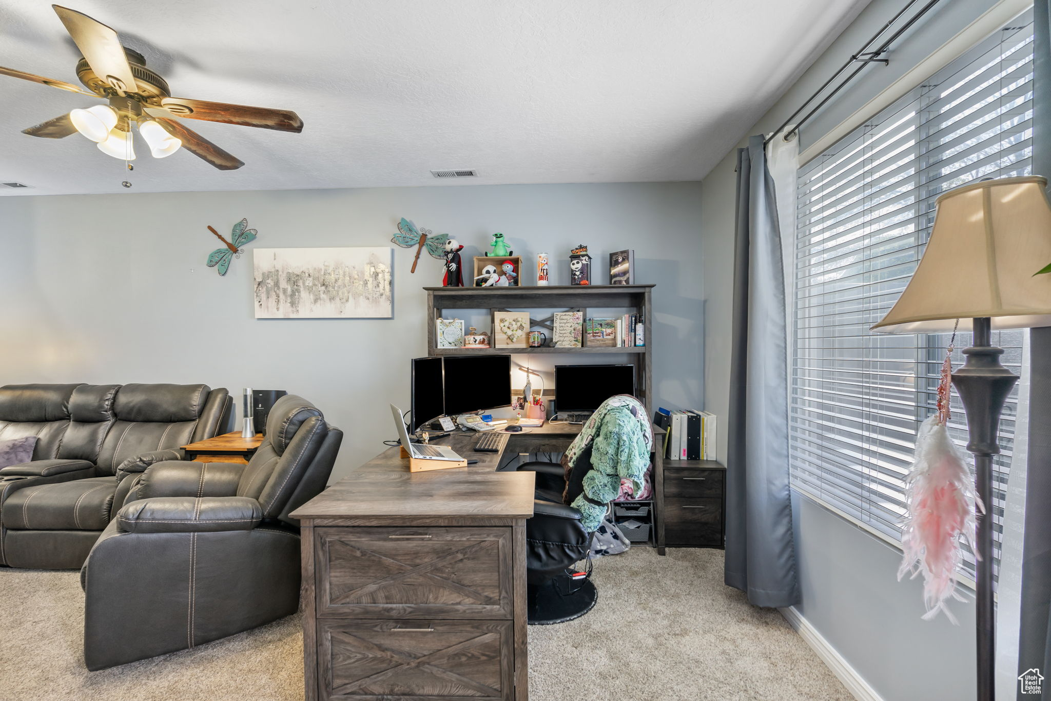 Carpeted office featuring ceiling fan