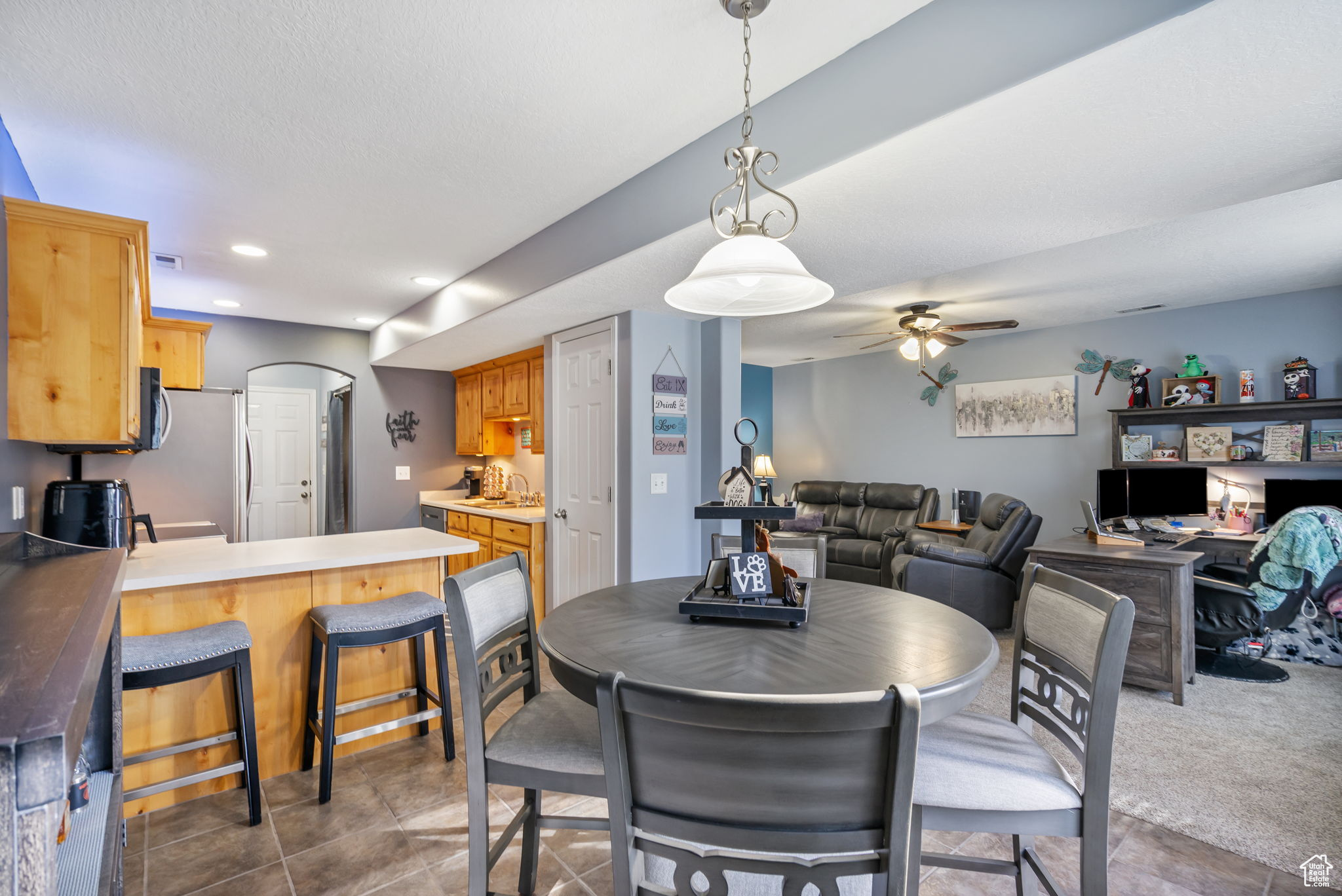 Tiled dining room featuring ceiling fan and sink