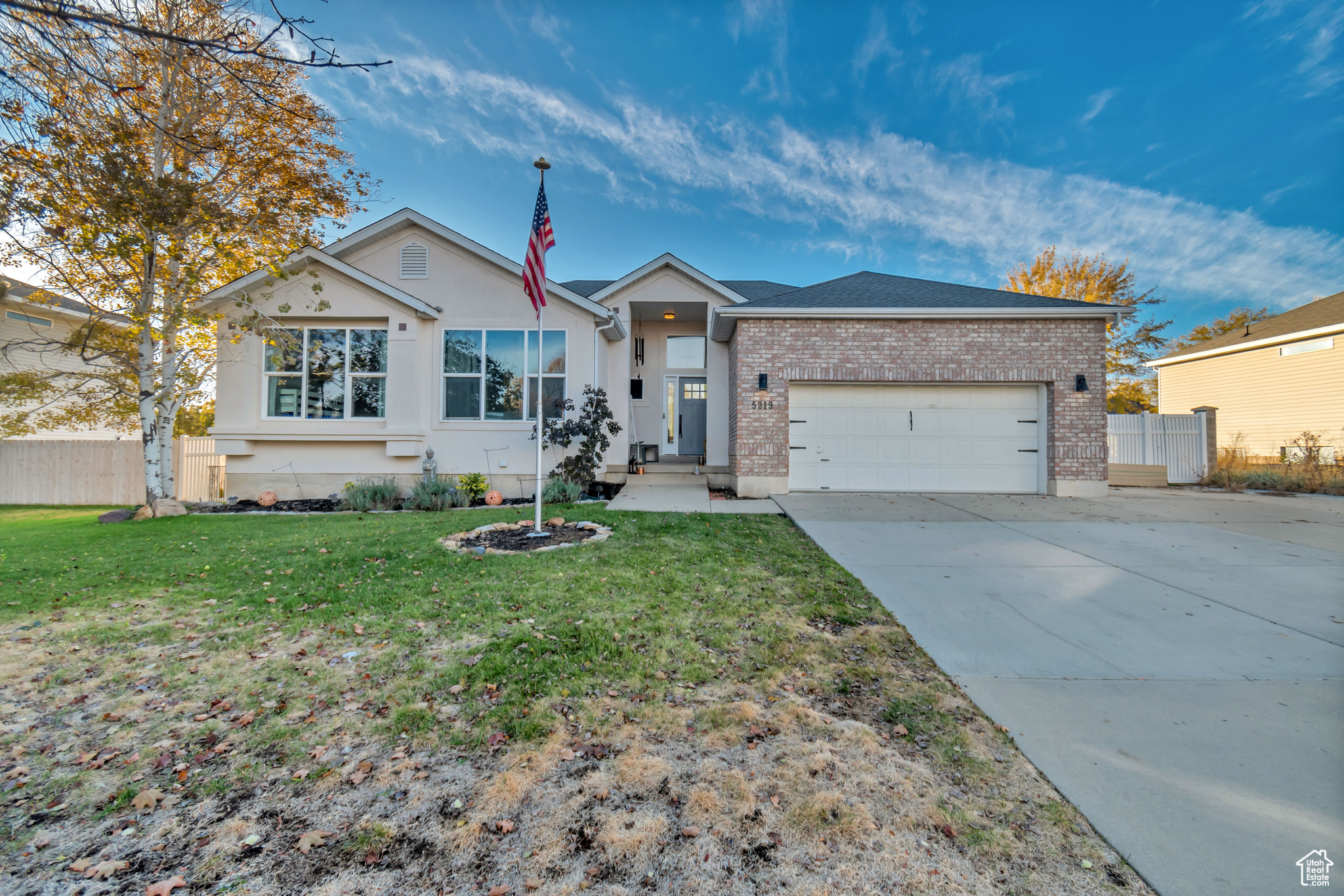 Single story home featuring a front yard and a garage