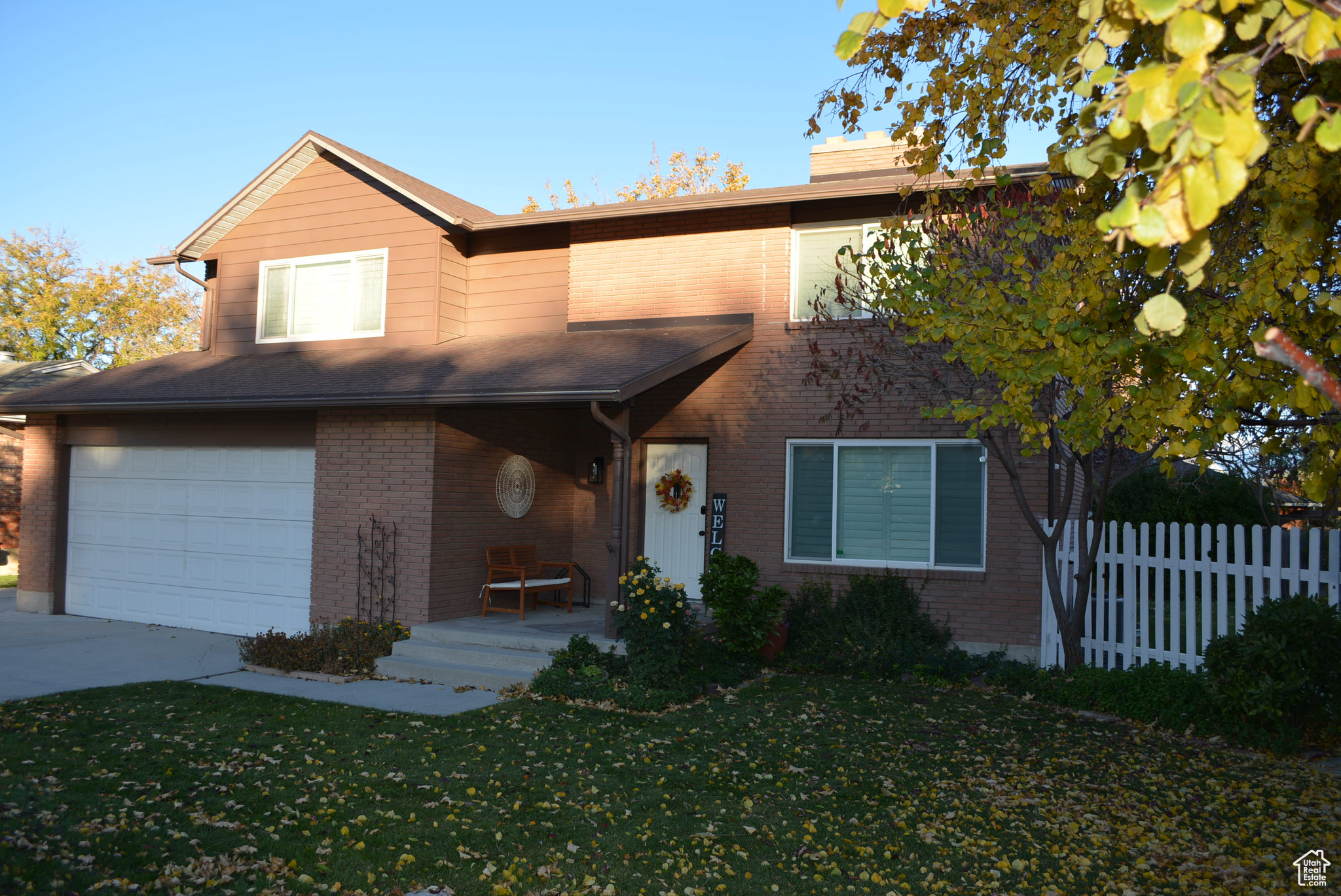 View of front of property featuring a garage and a front lawn