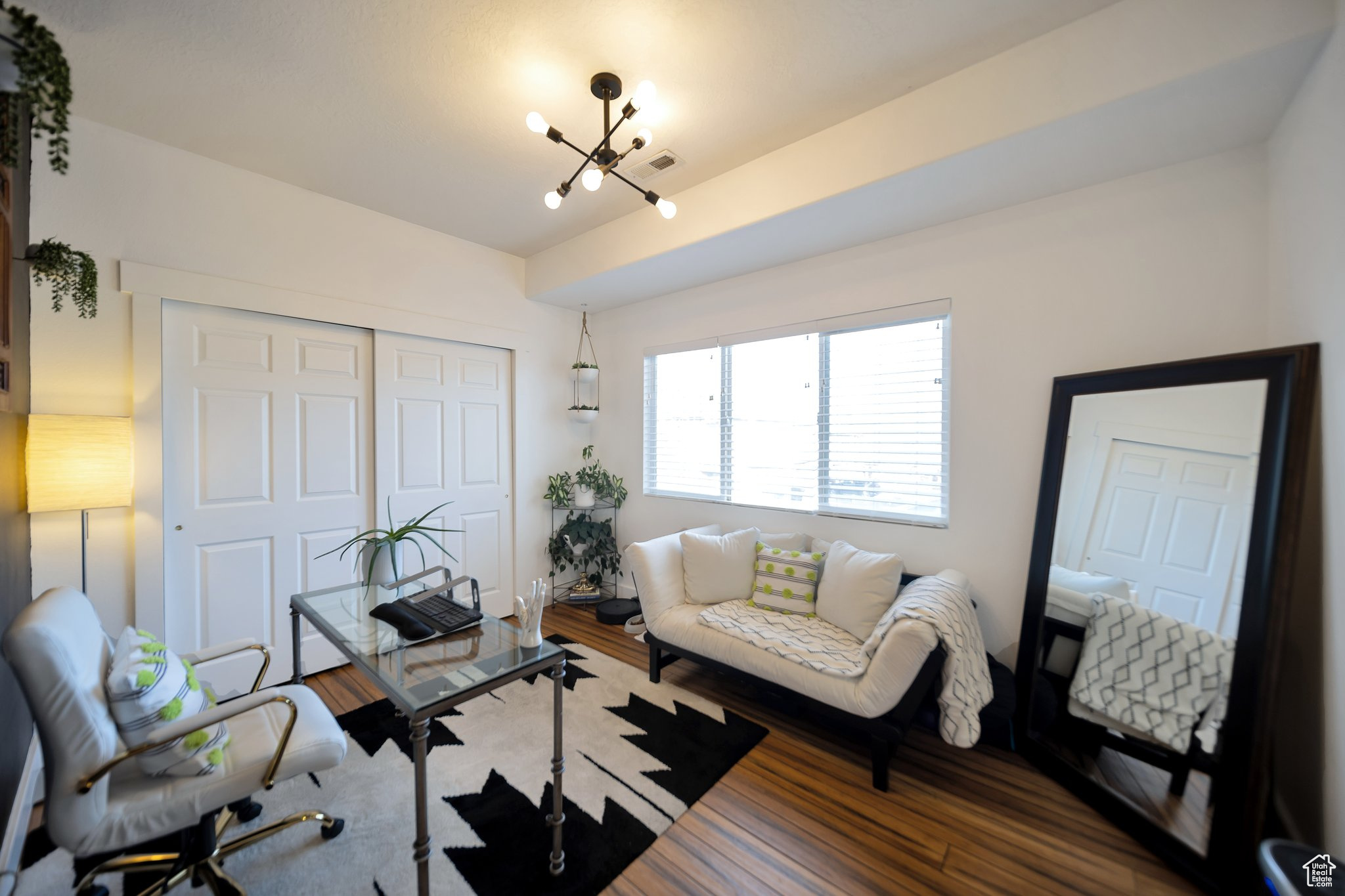 Living room with hardwood / wood-style floors, a chandelier, and vaulted ceiling