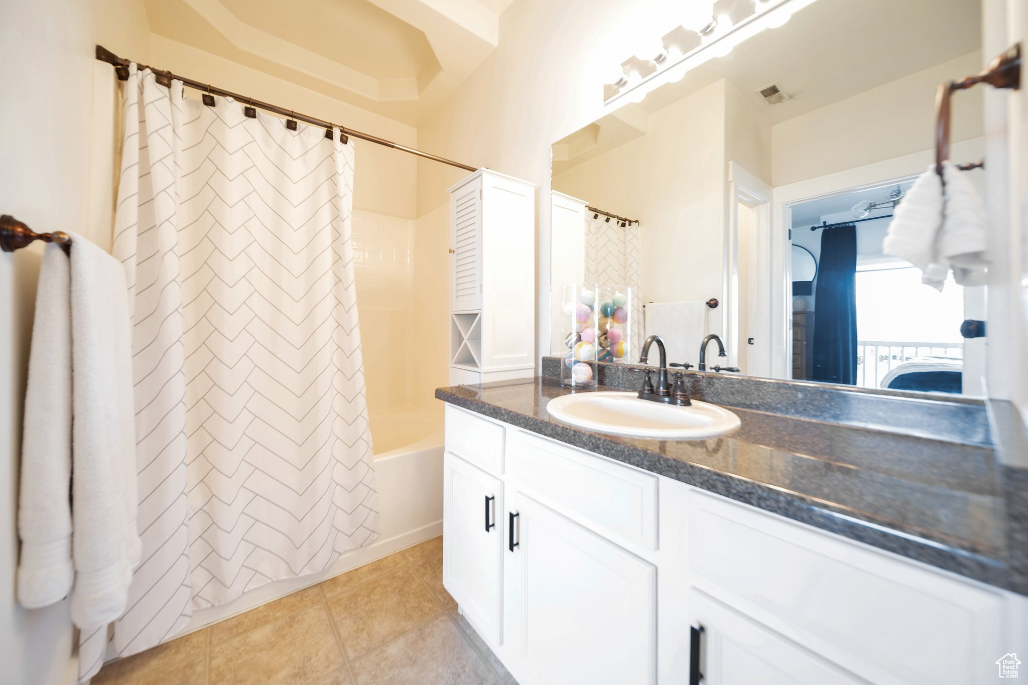 Bathroom featuring tile patterned flooring, vanity, and shower / tub combo