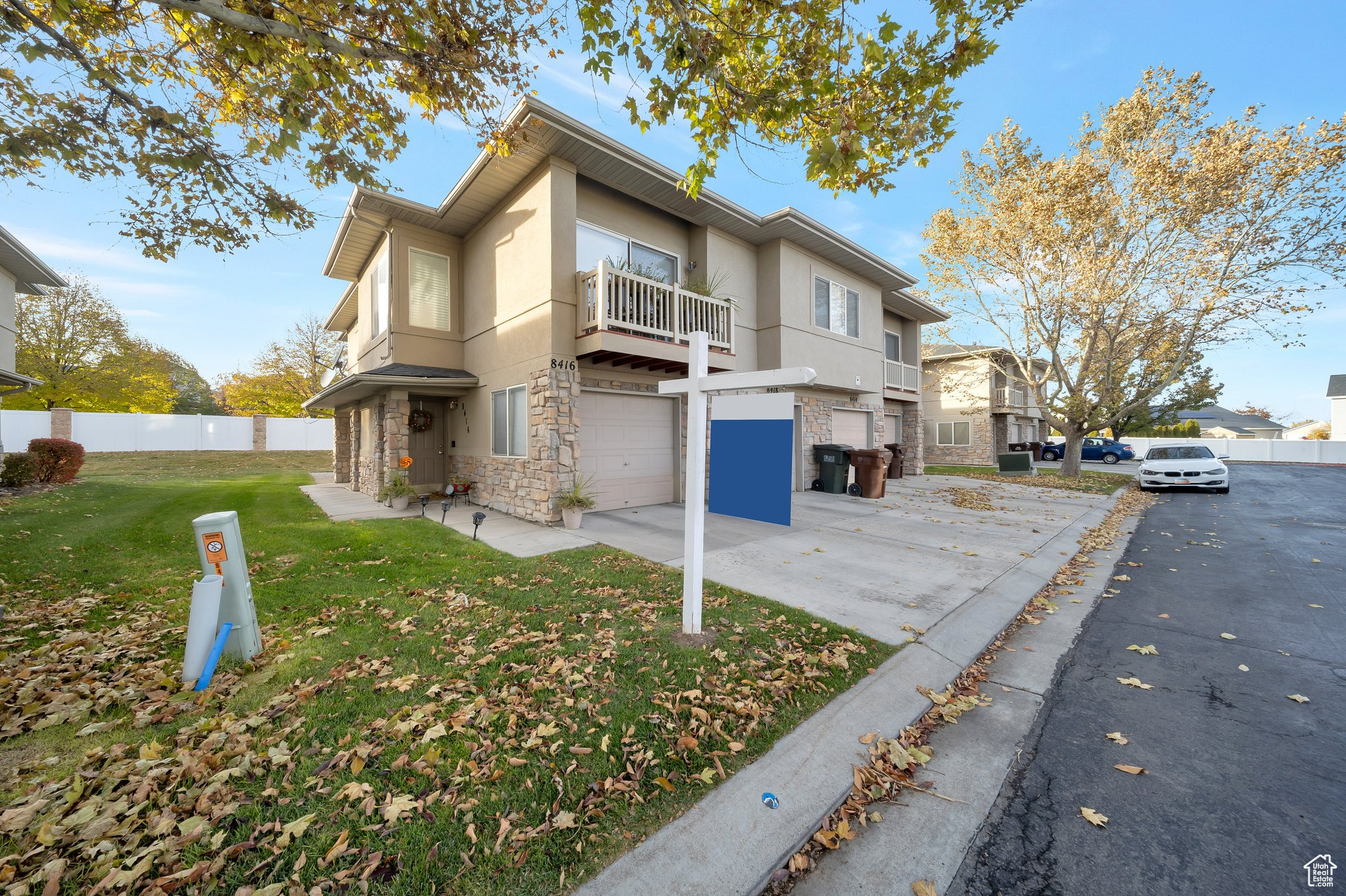 View of front of home featuring a balcony, a front lawn, and a garage