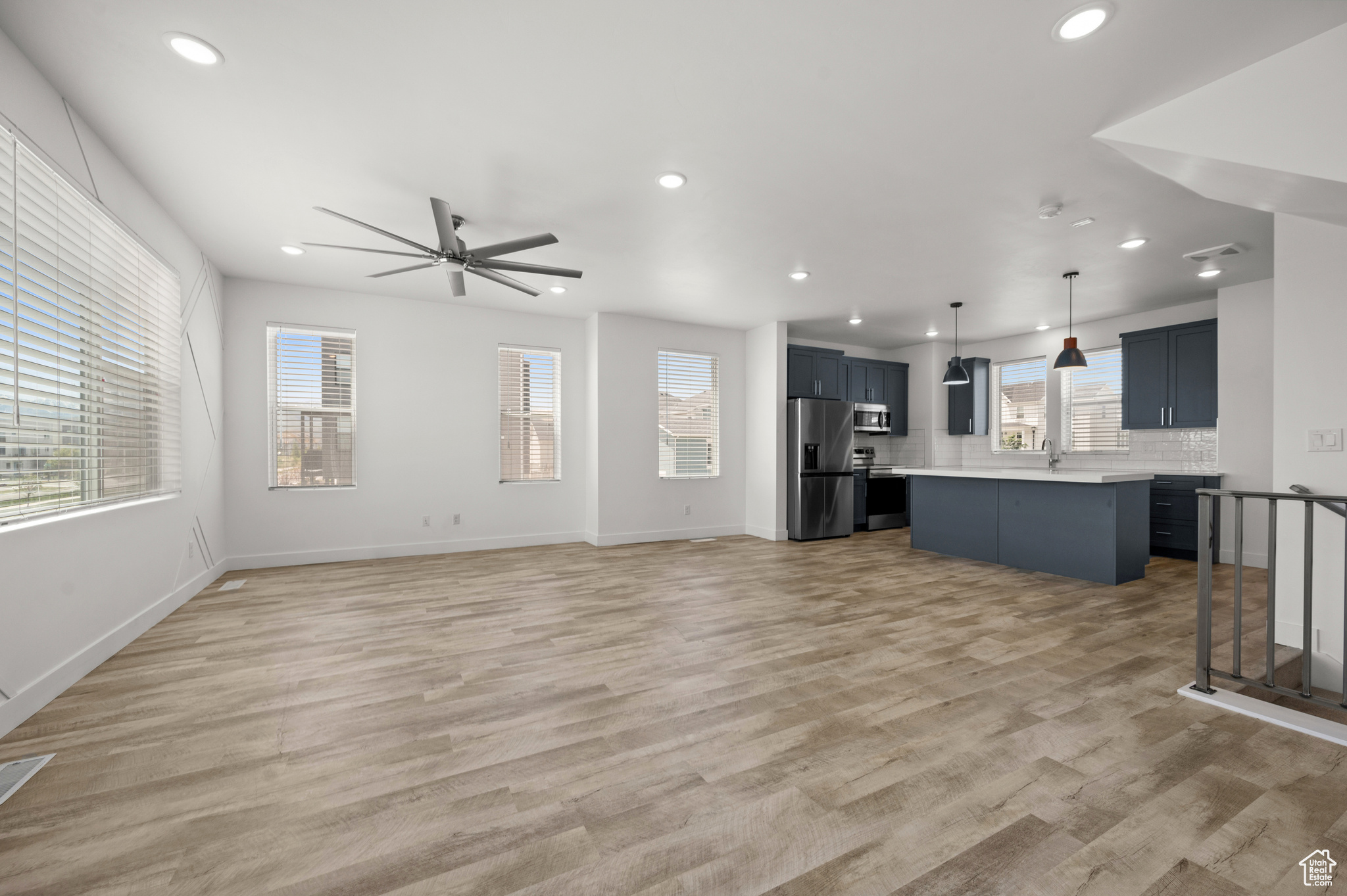 Living room with light hardwood / wood-style flooring, ceiling fan, and sink