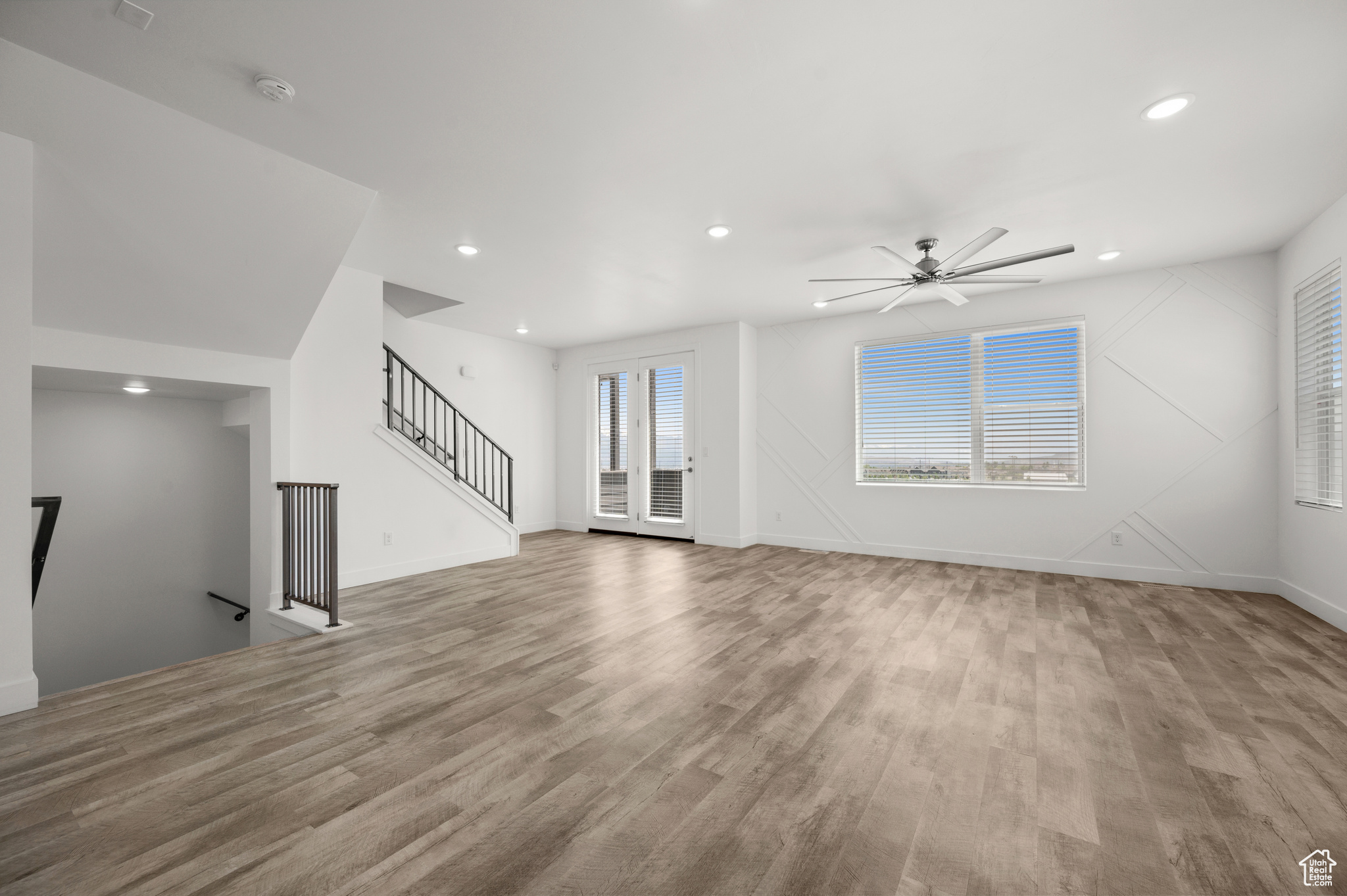 Unfurnished living room with ceiling fan and light wood-type flooring