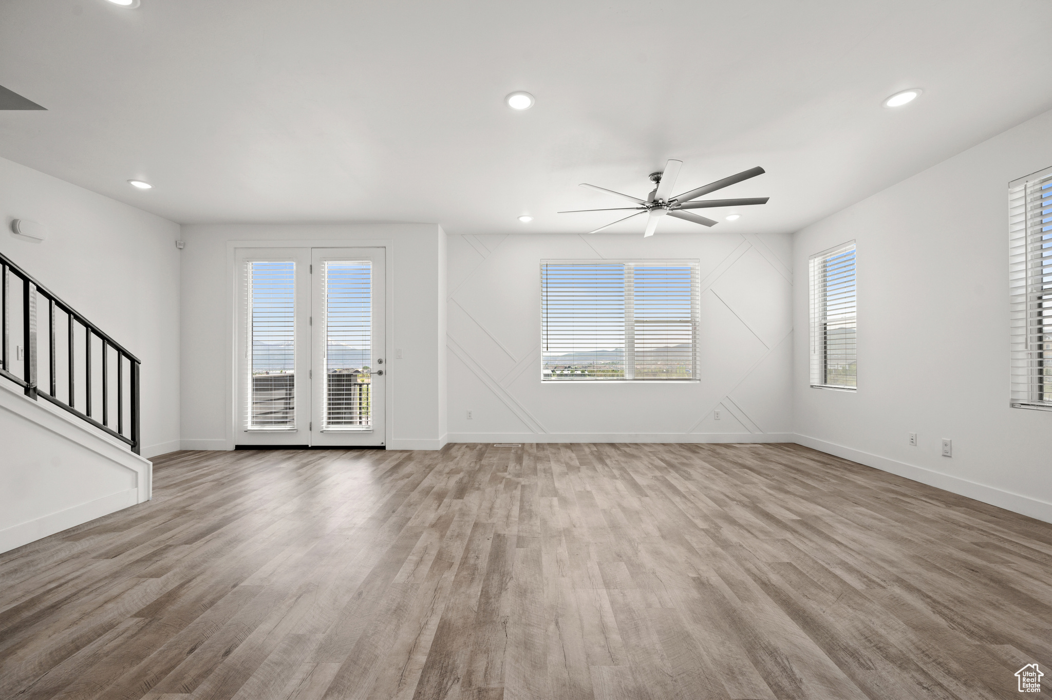 Unfurnished living room with hardwood / wood-style floors and ceiling fan