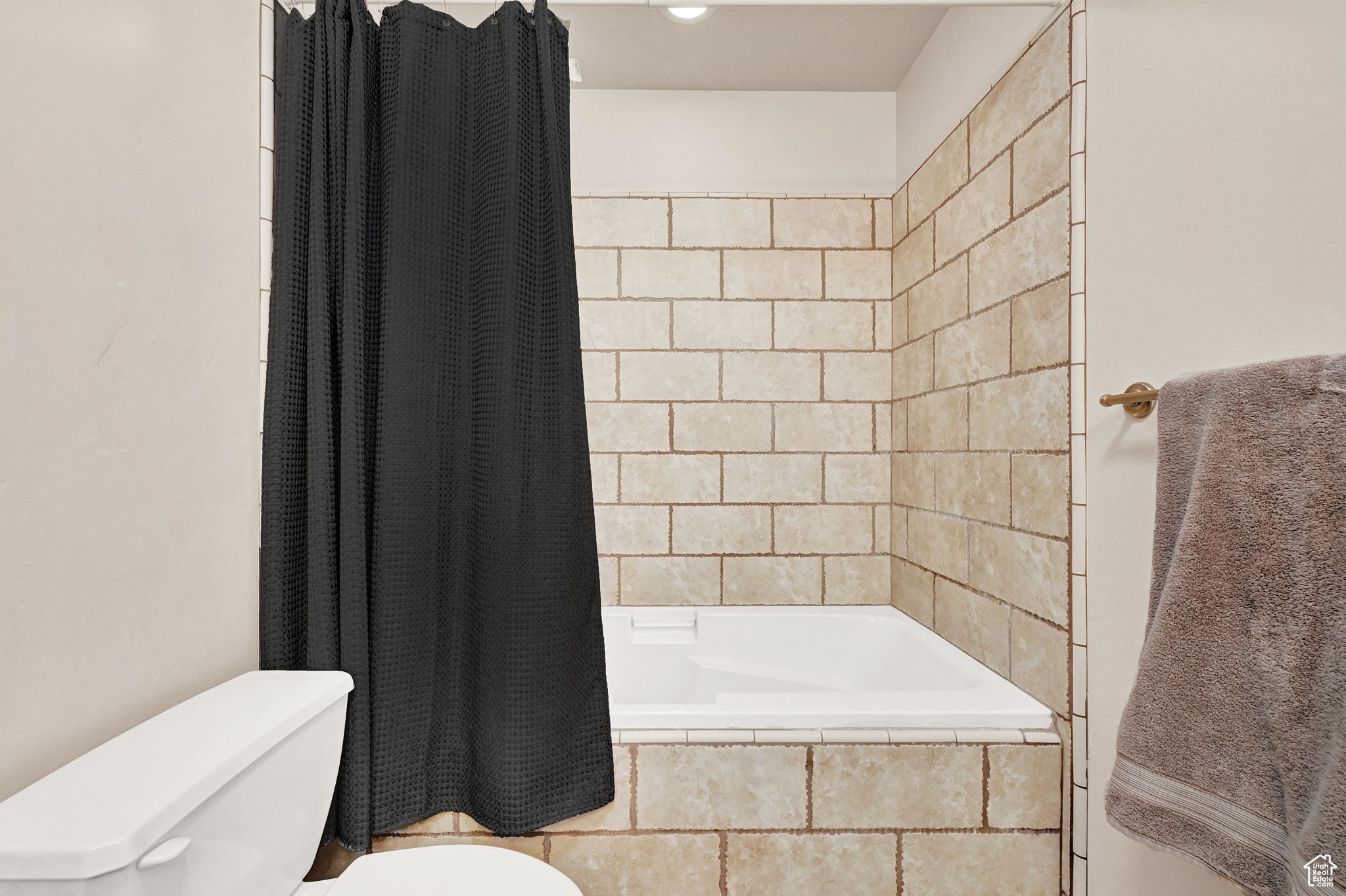 Bathroom with toilet and shower / tub combo with curtain