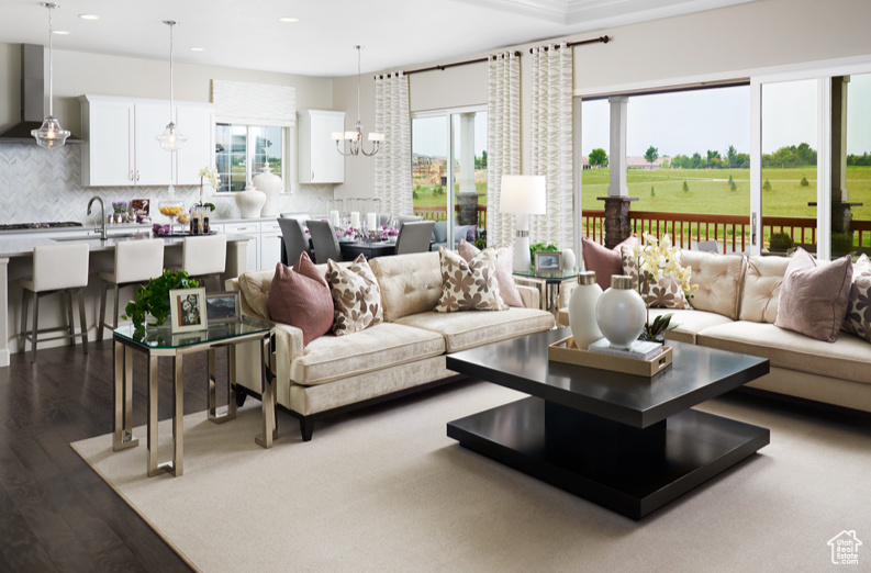 Living room with a chandelier, hardwood / wood-style floors, a wealth of natural light, and sink