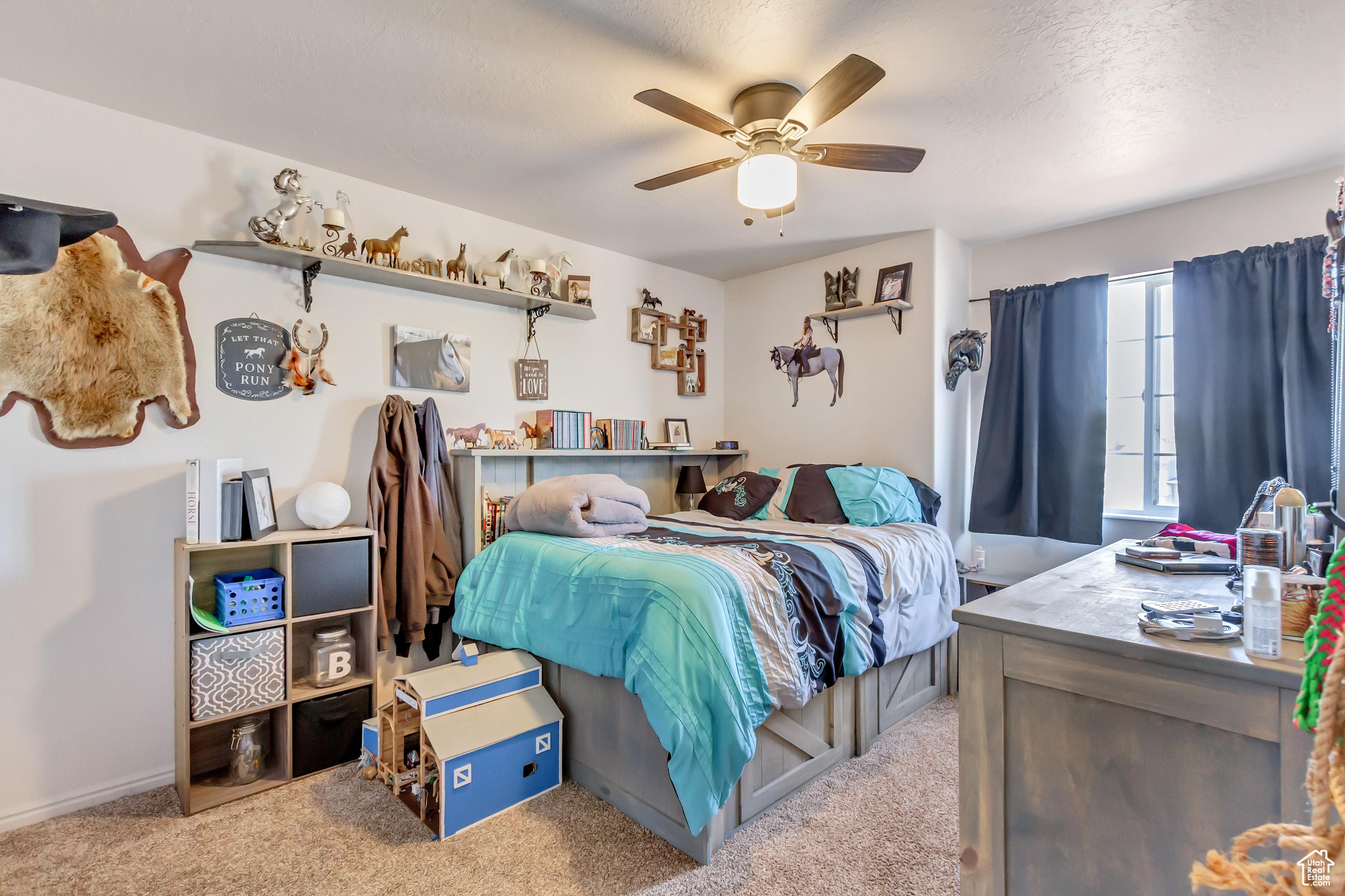 Carpeted bedroom with ceiling fan and a textured ceiling