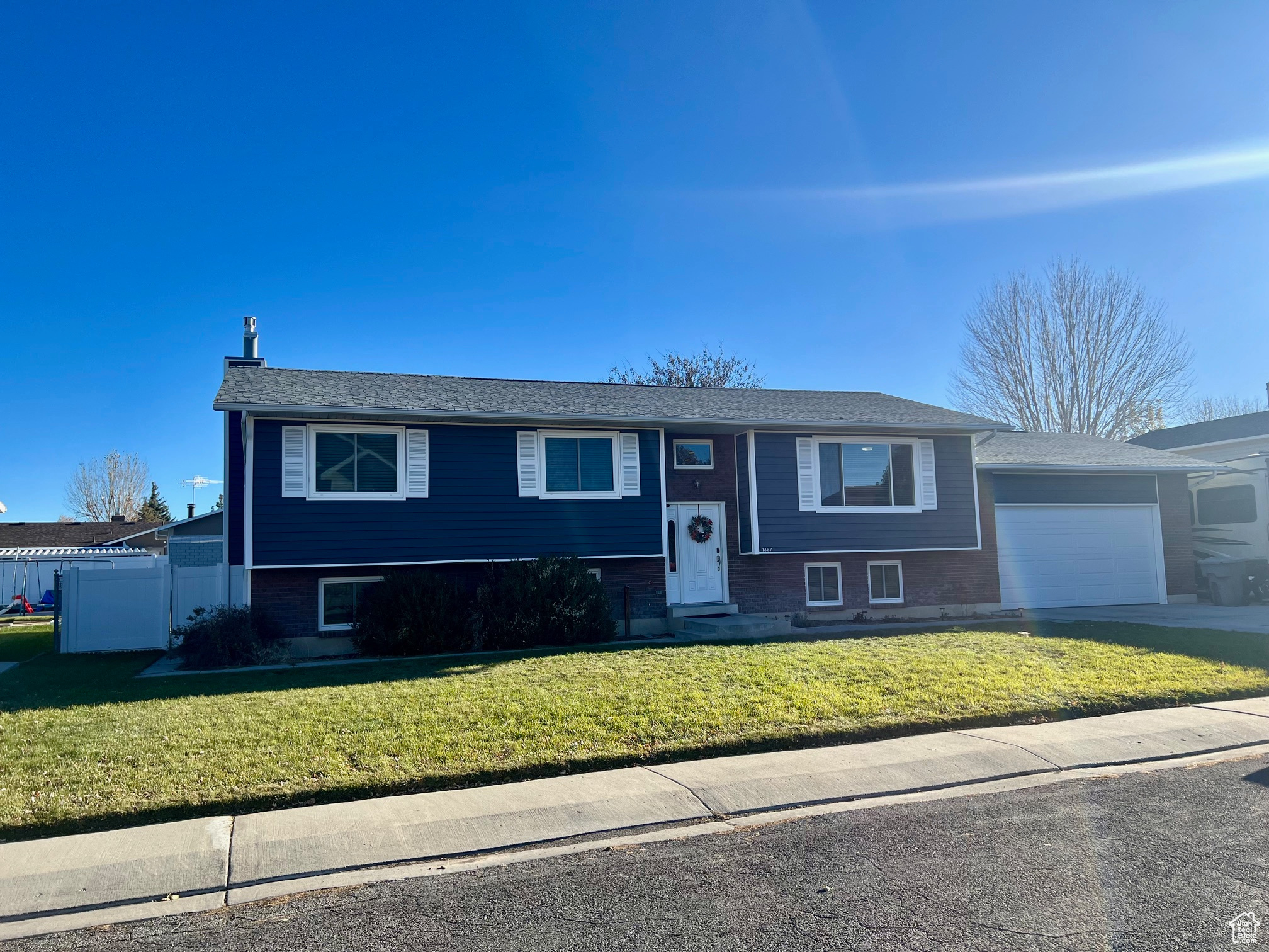 Bi-level home with a front yard and a garage