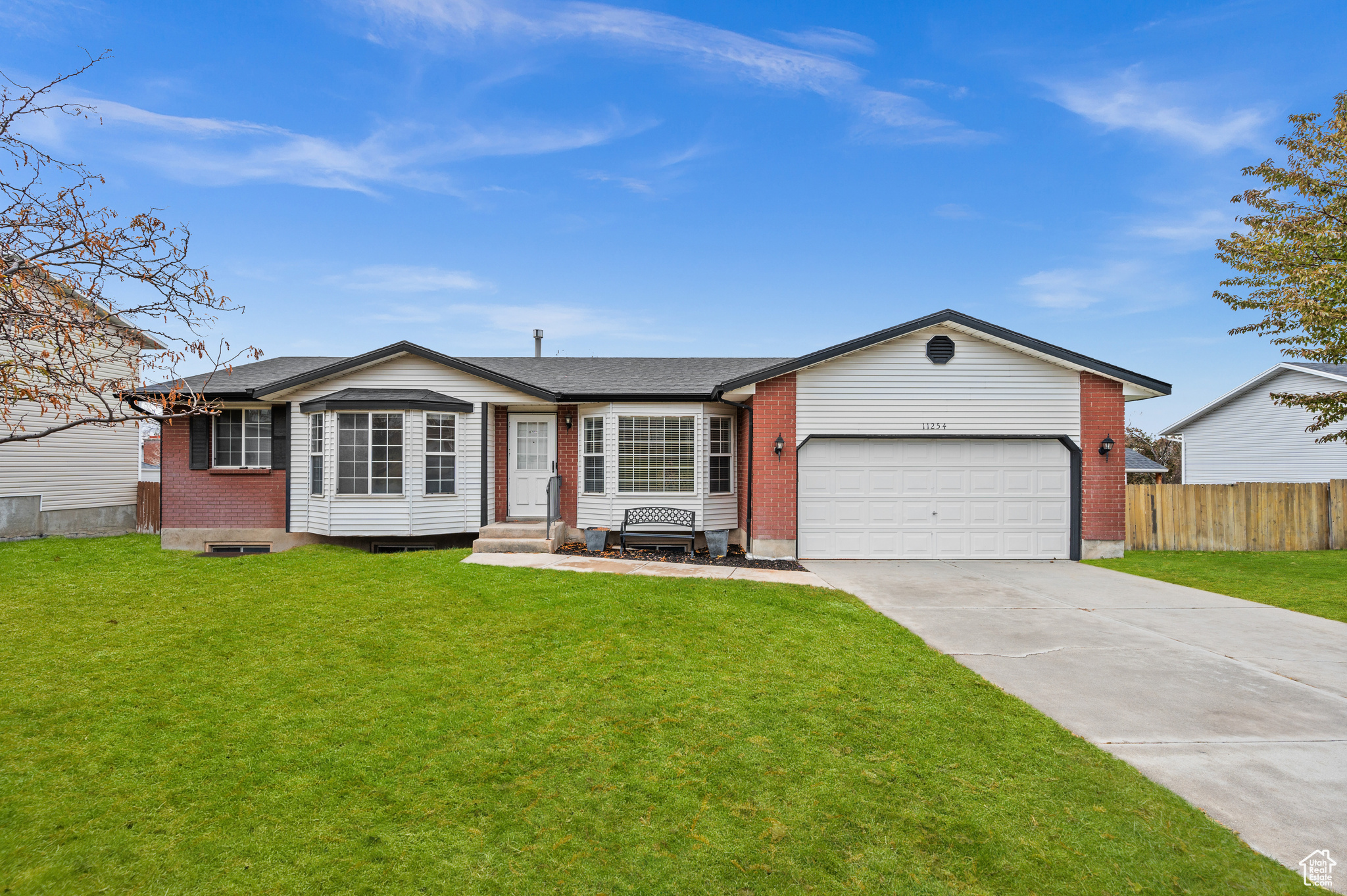 Ranch-style home featuring a garage and a front lawn