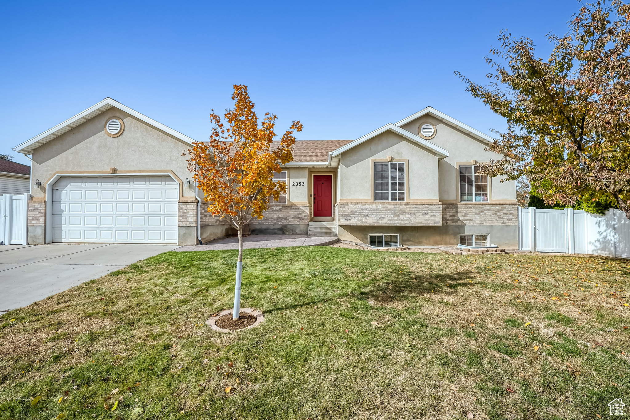 View of front of property with a front lawn, central AC unit, and a garage