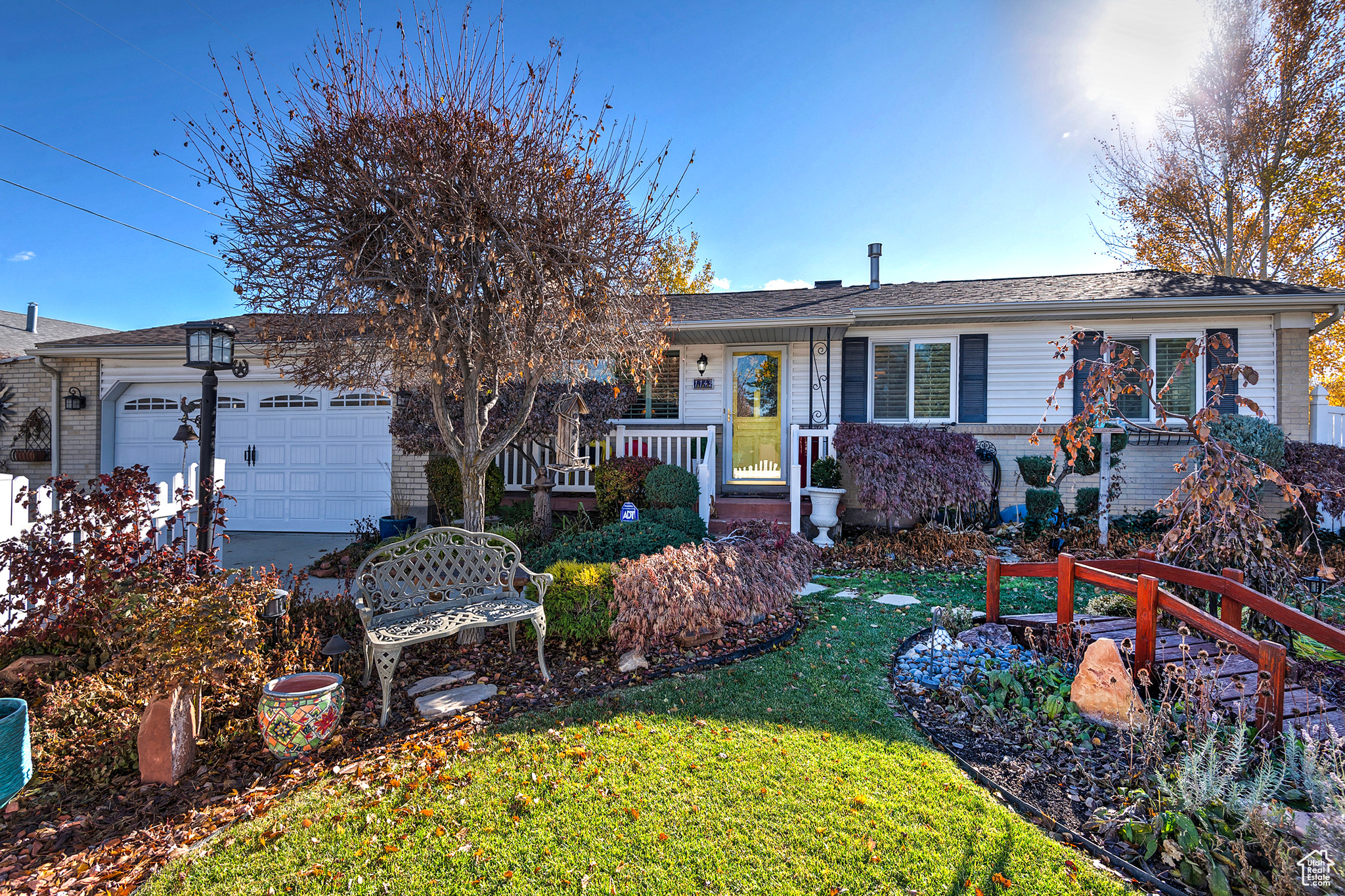 Single story home with a garage and a front lawn