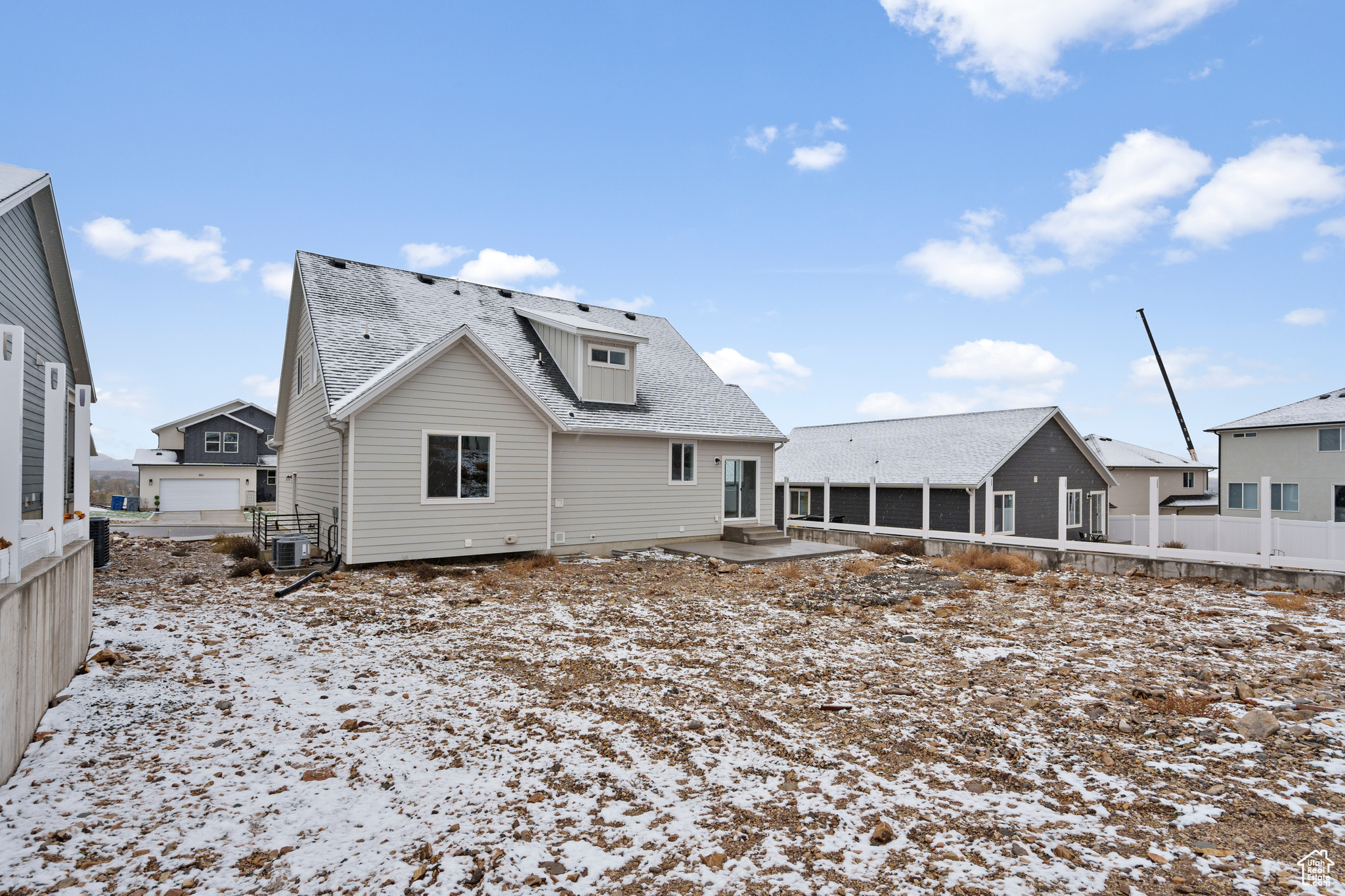 Snow covered back of property featuring central AC