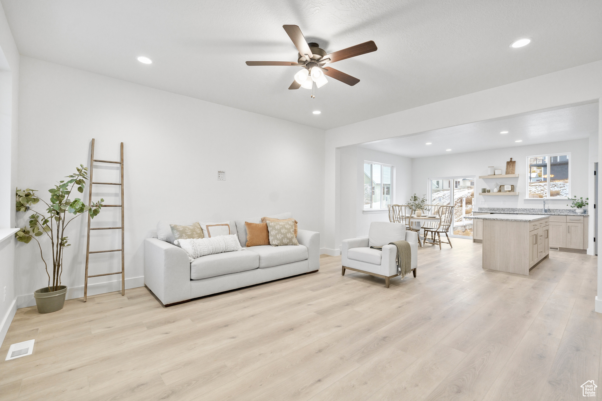 Living room with ceiling fan, sink, and light hardwood / wood-style floors