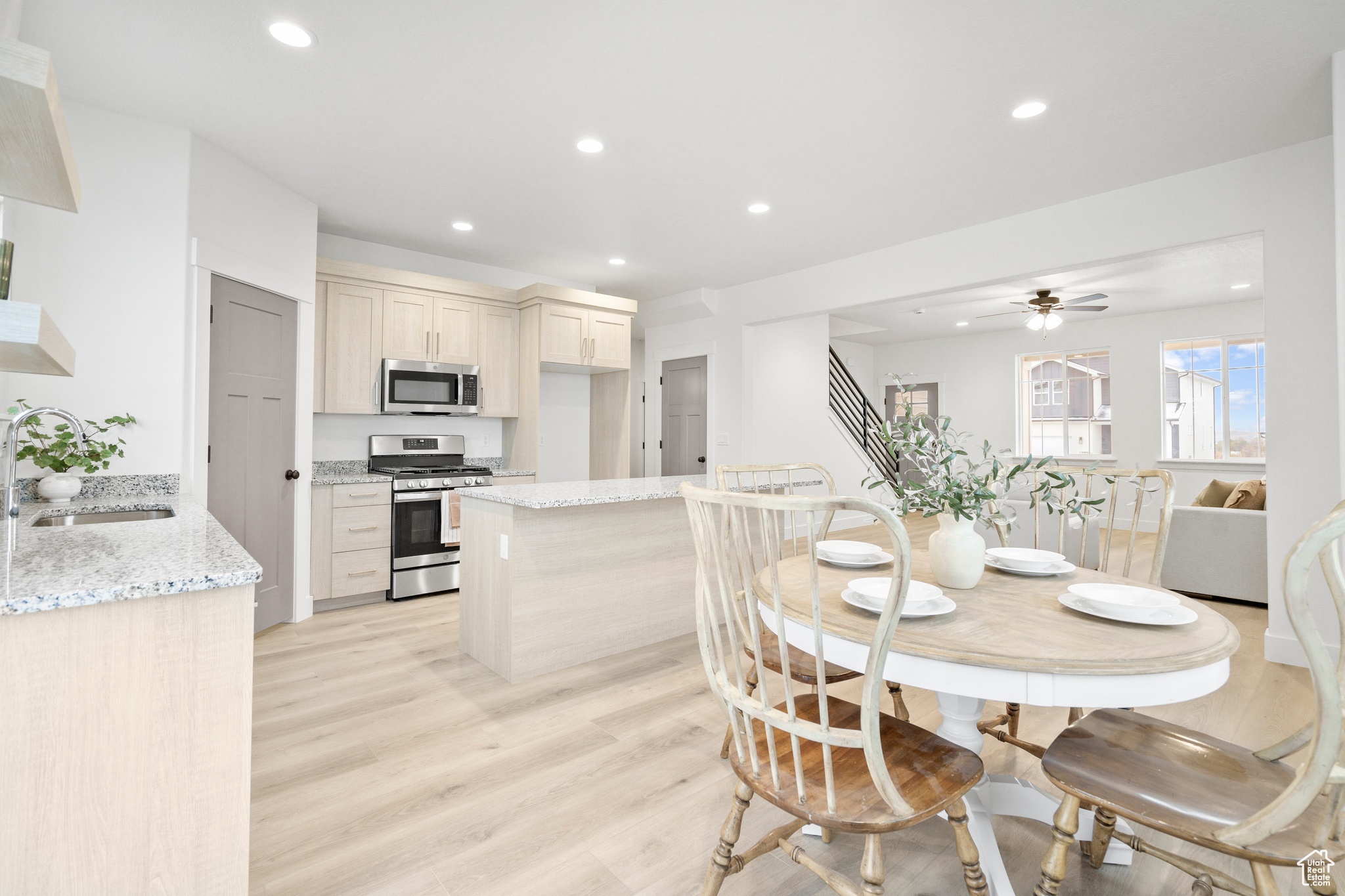 Dining area featuring ceiling fan, sink, and light hardwood / wood-style flooring