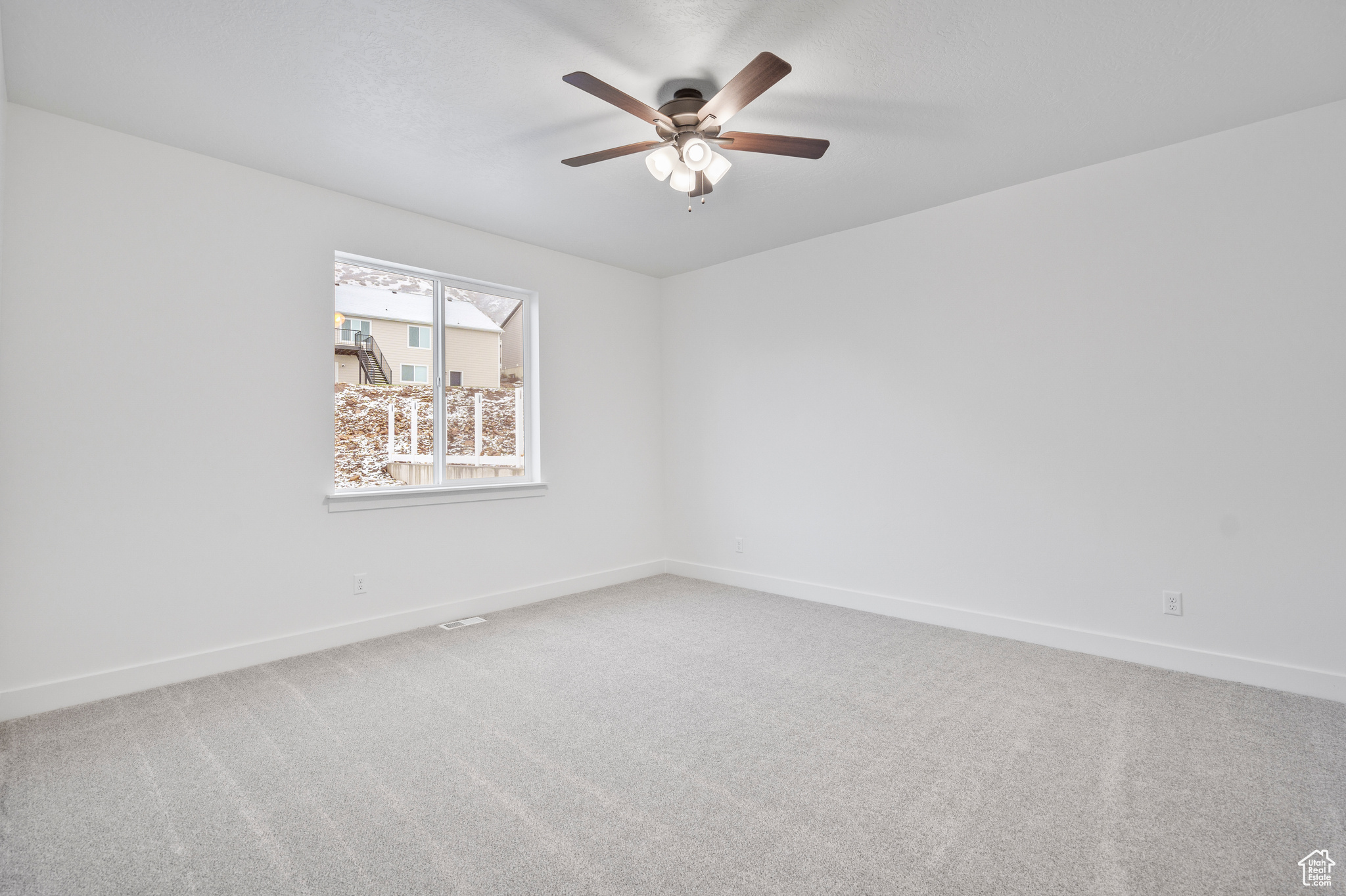 Spare room with carpet and ceiling fan