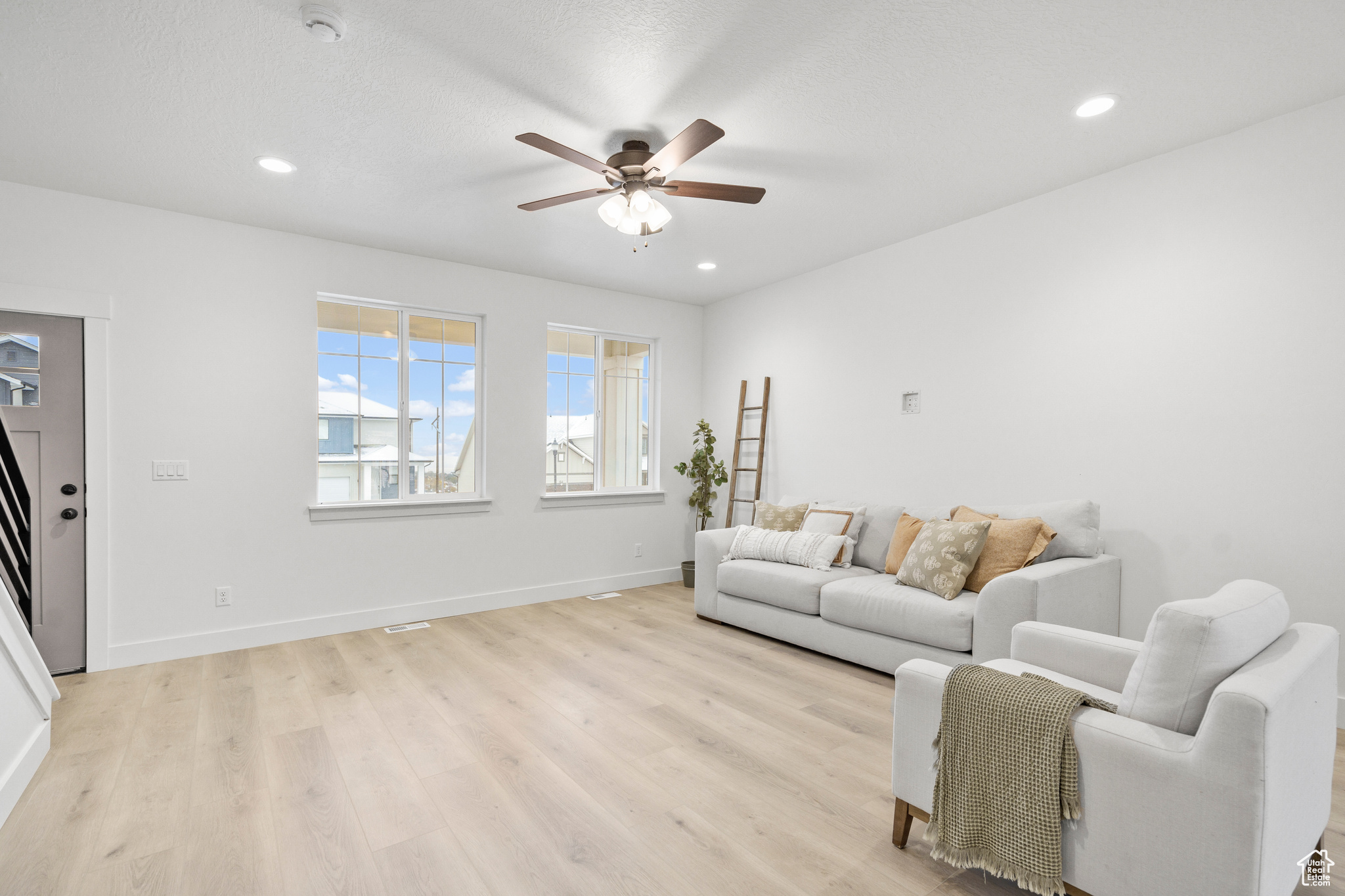 Living room featuring ceiling fan and light hardwood / wood-style floors