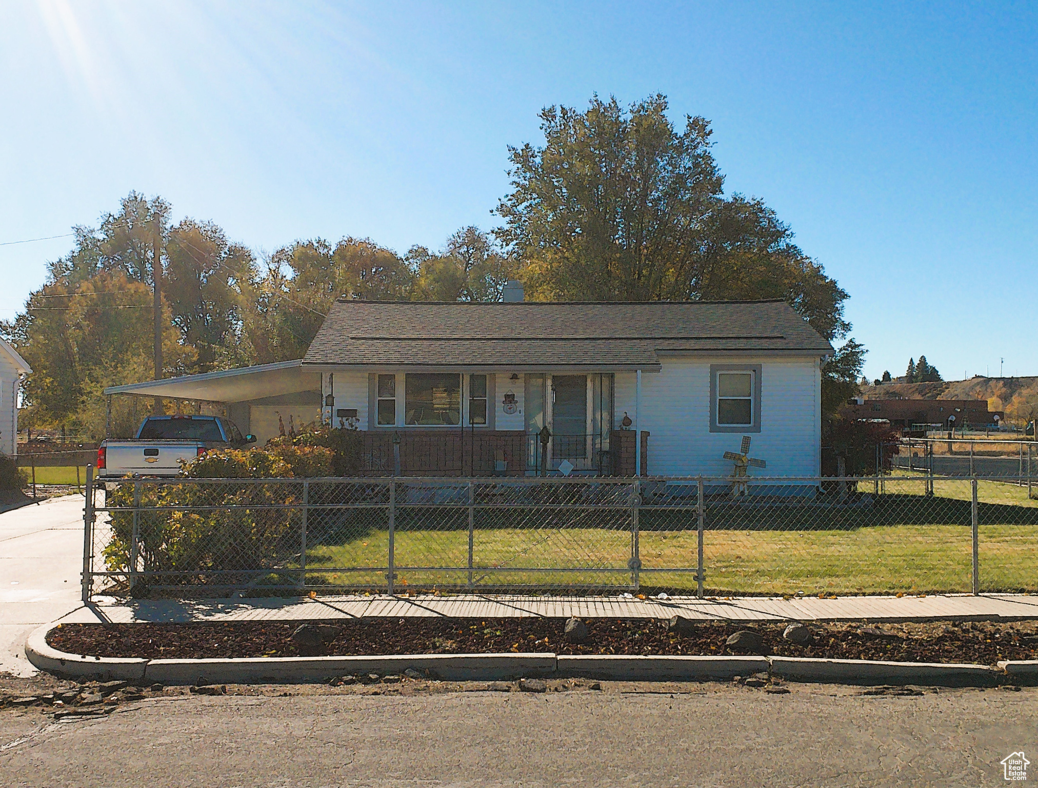 View of front of house featuring a front yard, a porch, and a carport