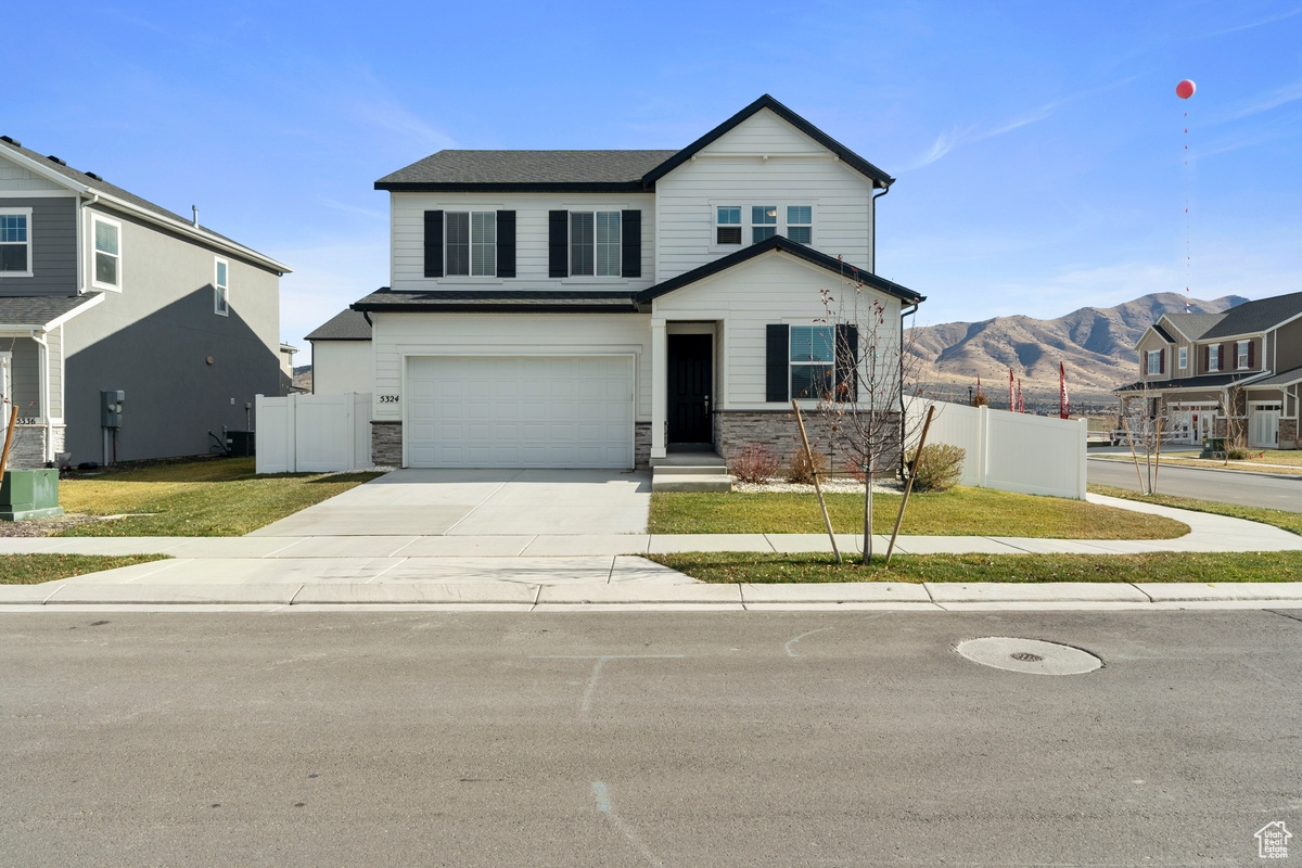 View of front of home with a mountain view and a garage