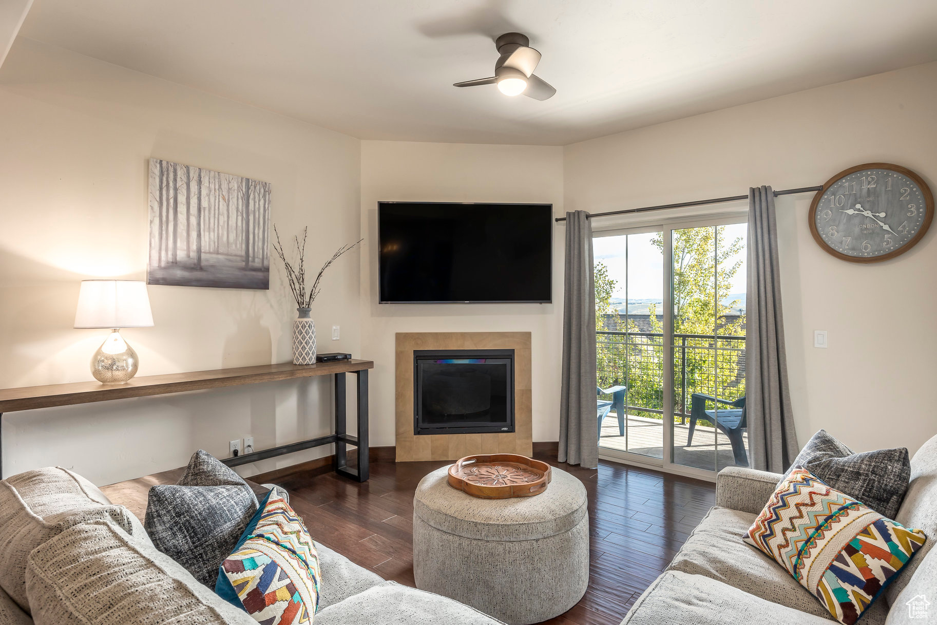 Living room with ceiling fan and dark wood-type flooring