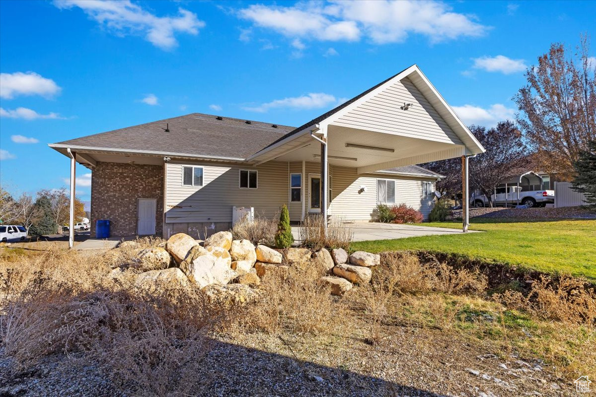 Rear view of property with a yard and a patio area