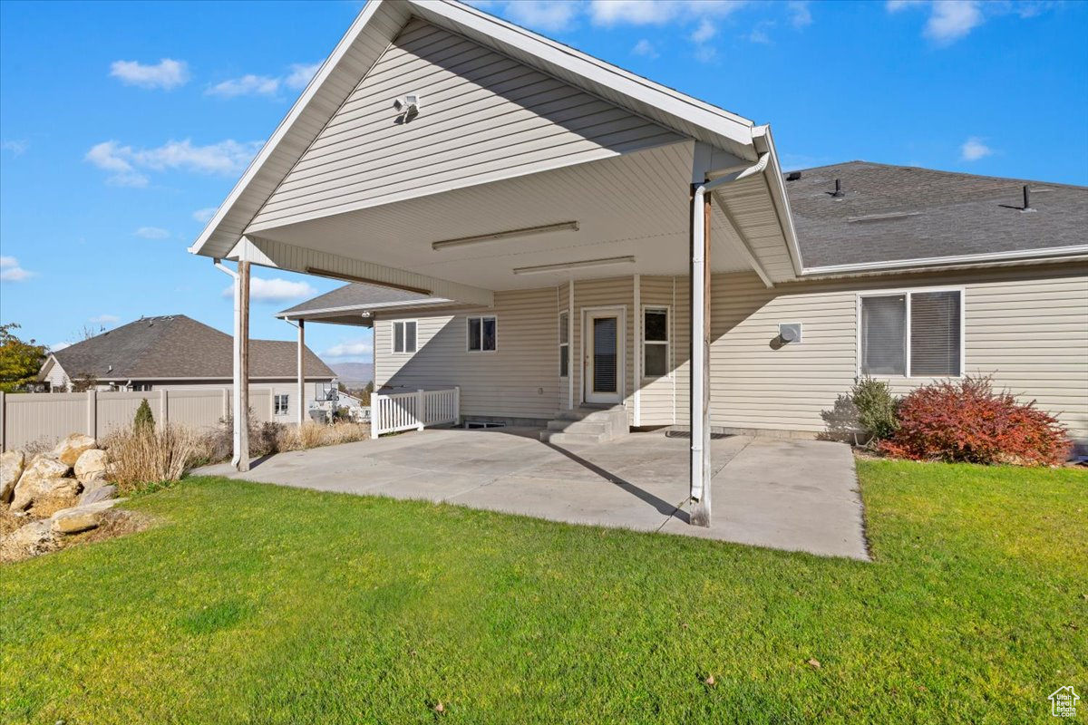 Rear view of house featuring a lawn and a patio