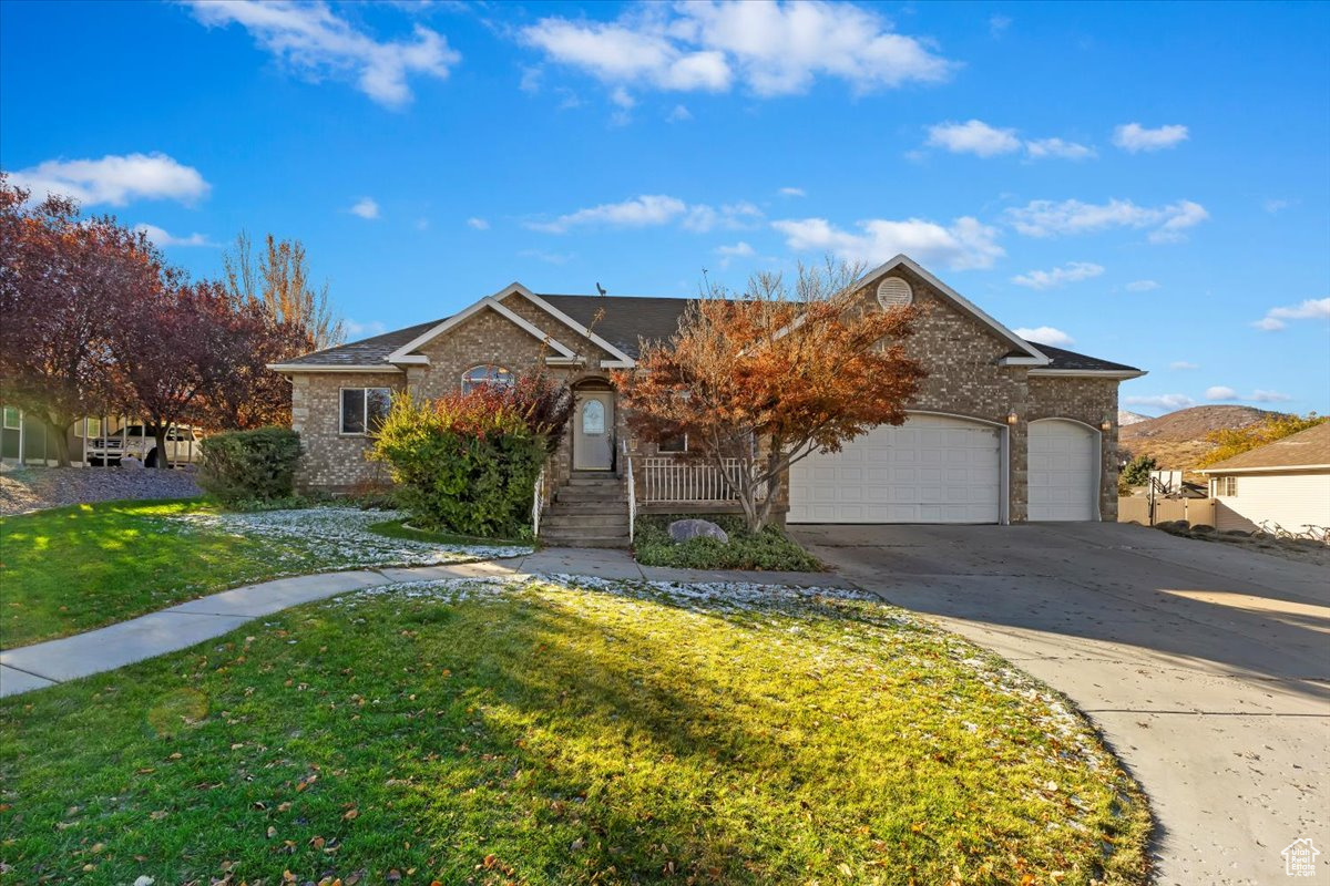 View of front of house with a garage and a front lawn