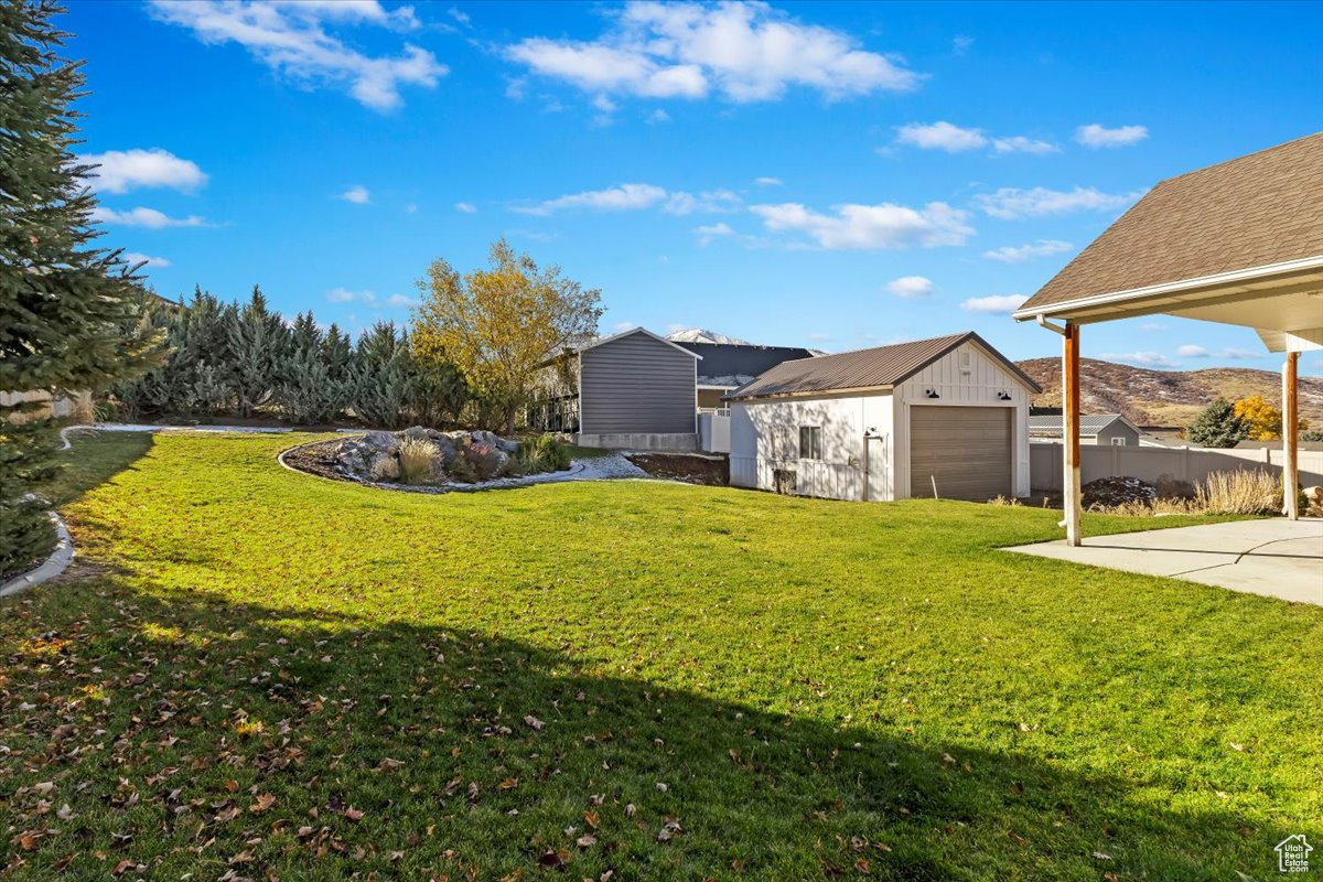 View of yard featuring a garage and a storage unit