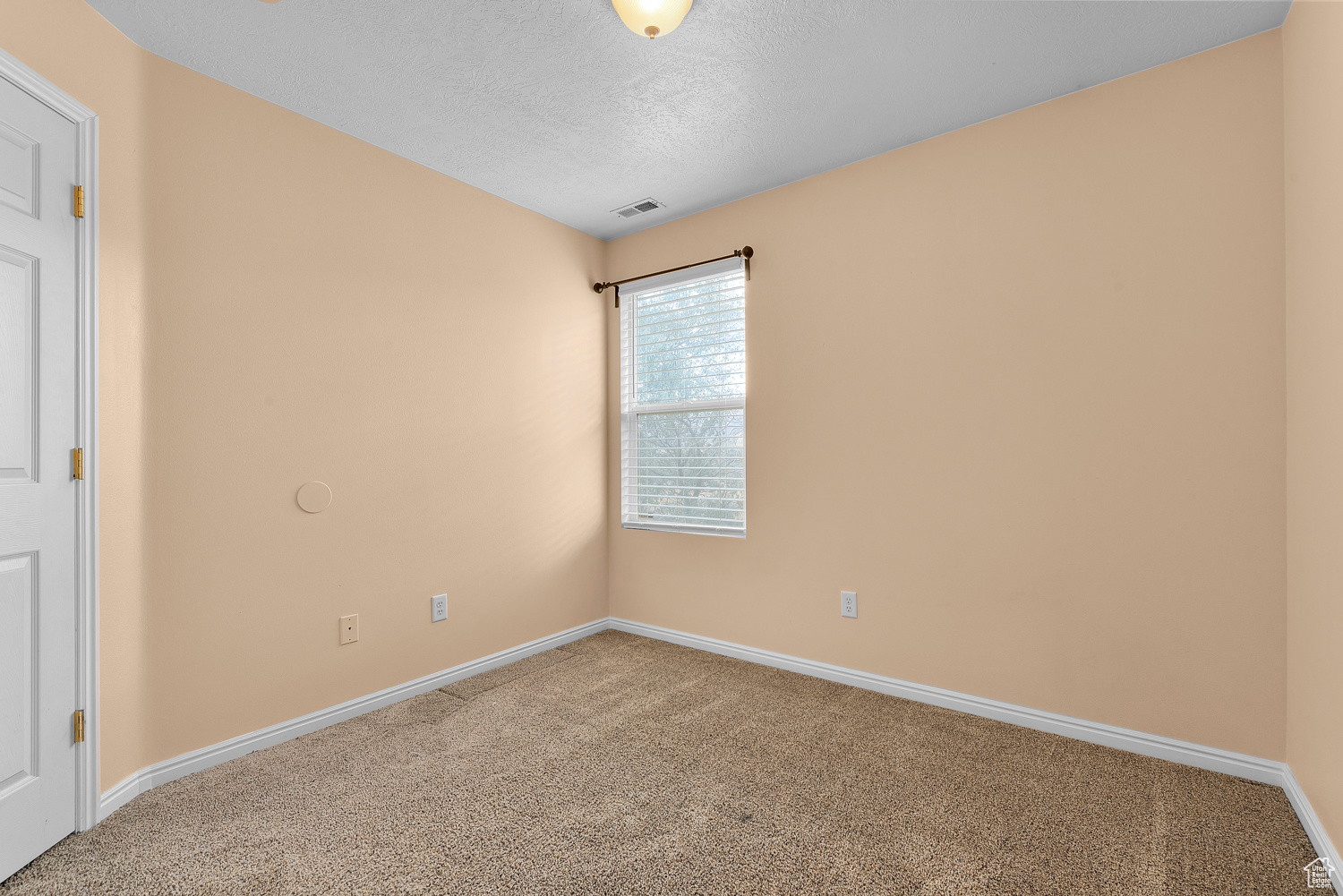 Carpeted spare room with a textured ceiling