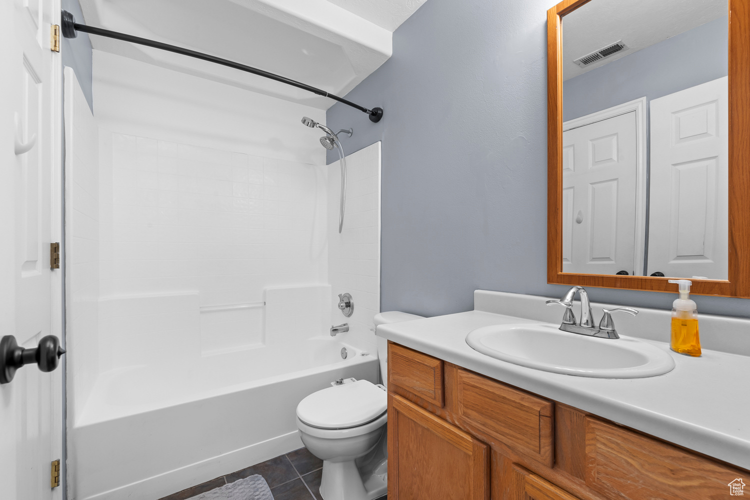 Full bathroom with tile patterned flooring, vanity, shower / bathtub combination, and toilet