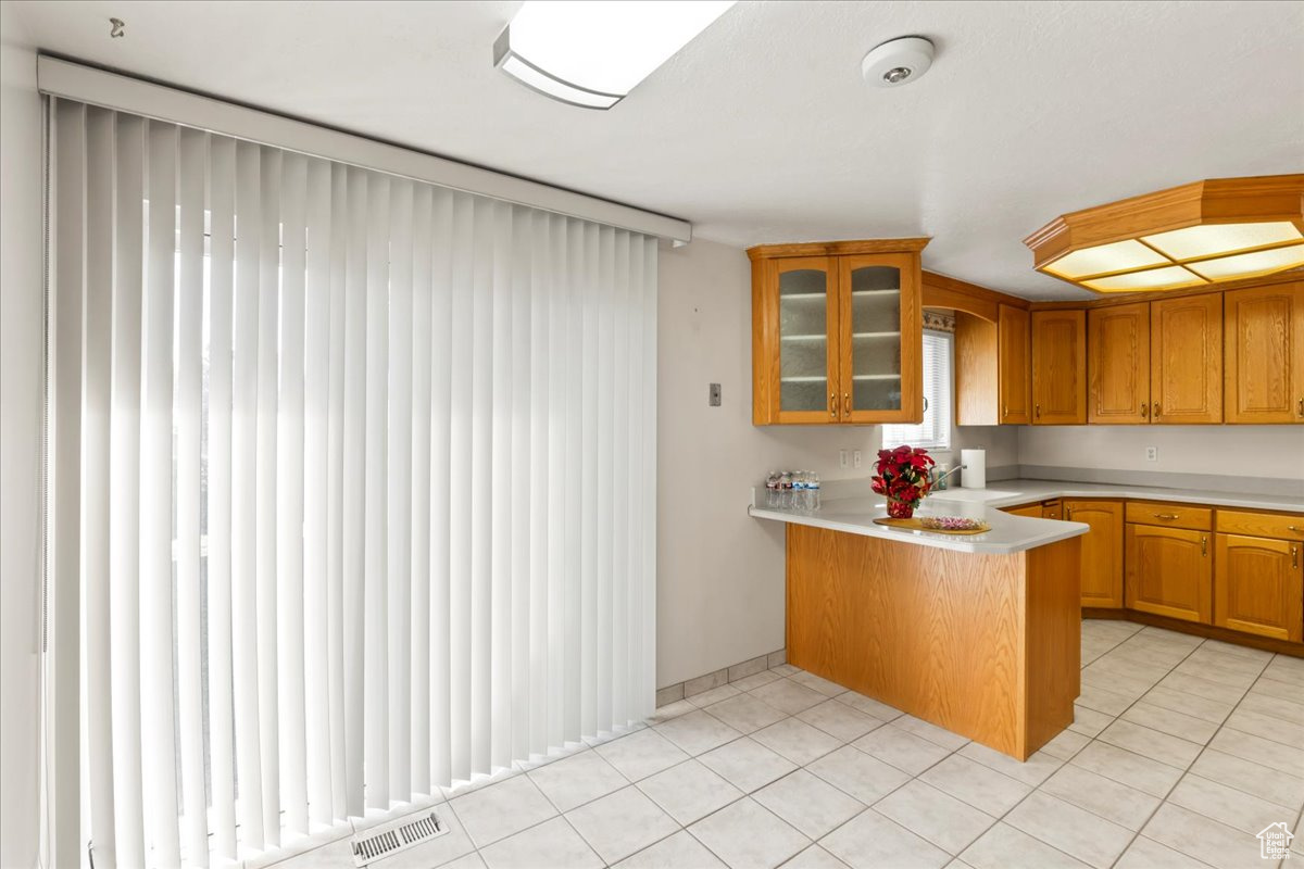 Kitchen featuring kitchen peninsula, a kitchen bar, and light tile patterned flooring