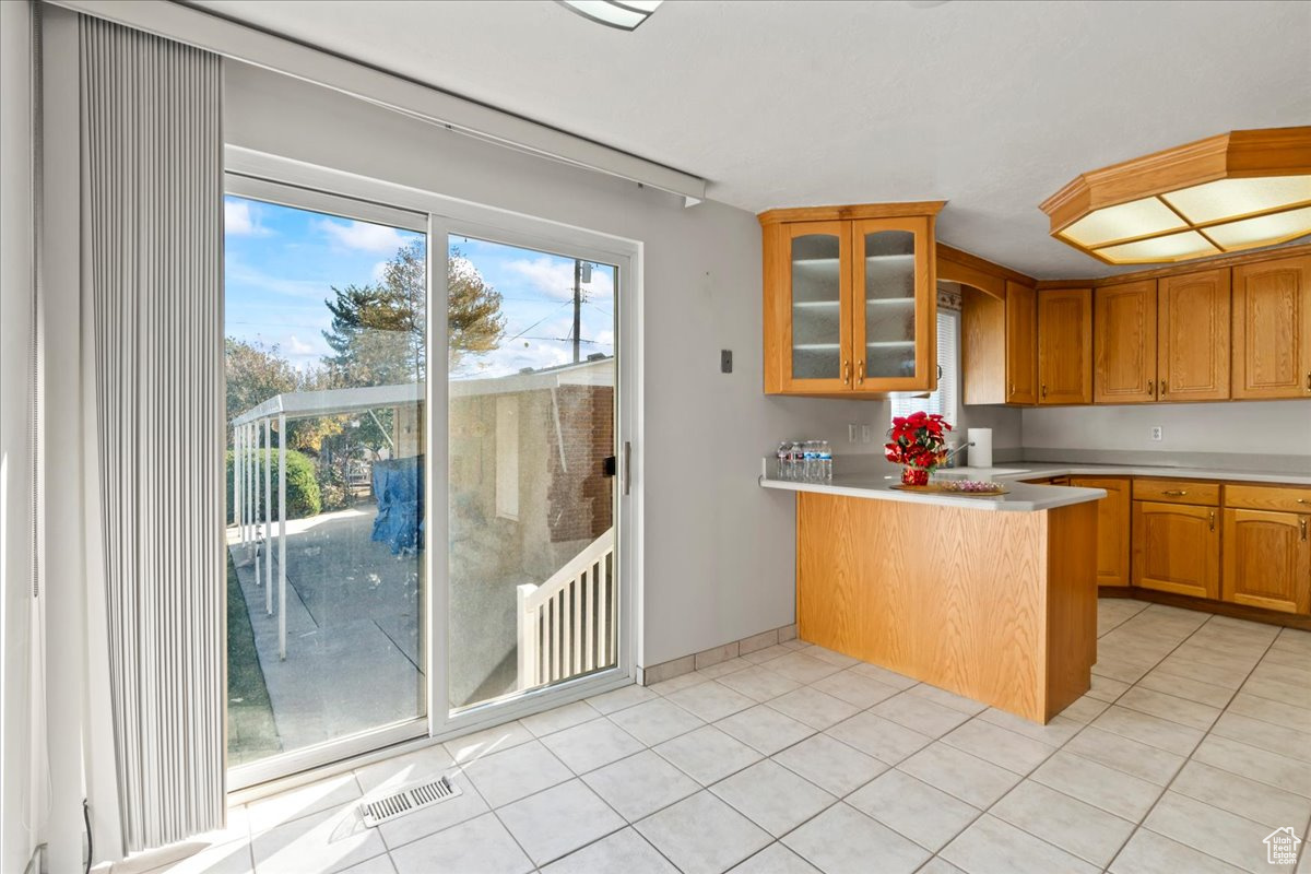 Kitchen featuring kitchen peninsula and light tile patterned floors