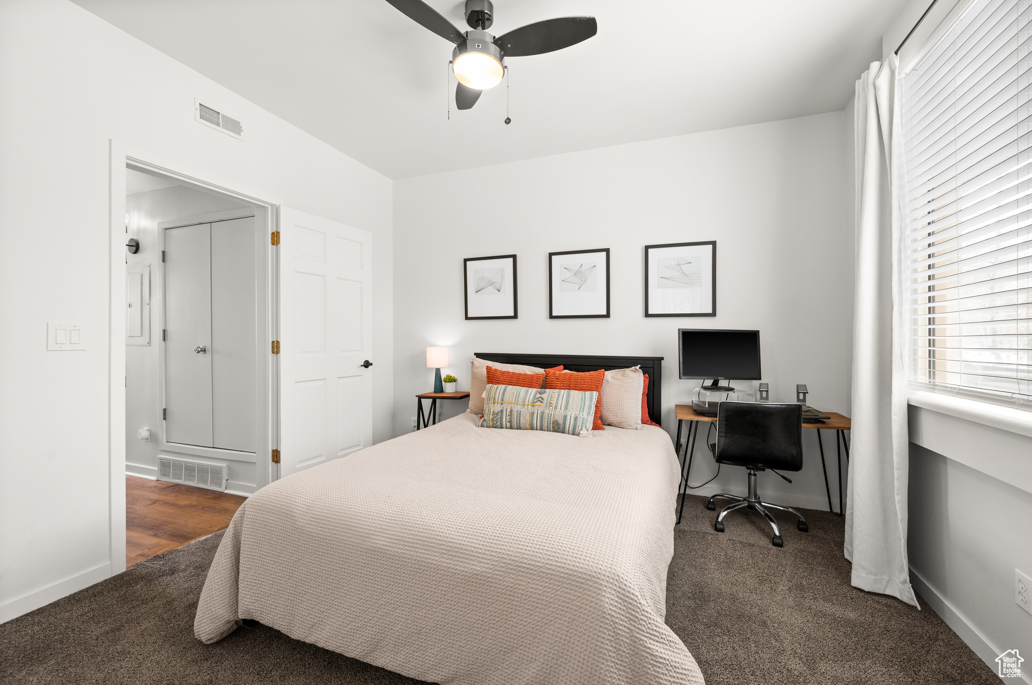 Bedroom with dark colored carpet and ceiling fan