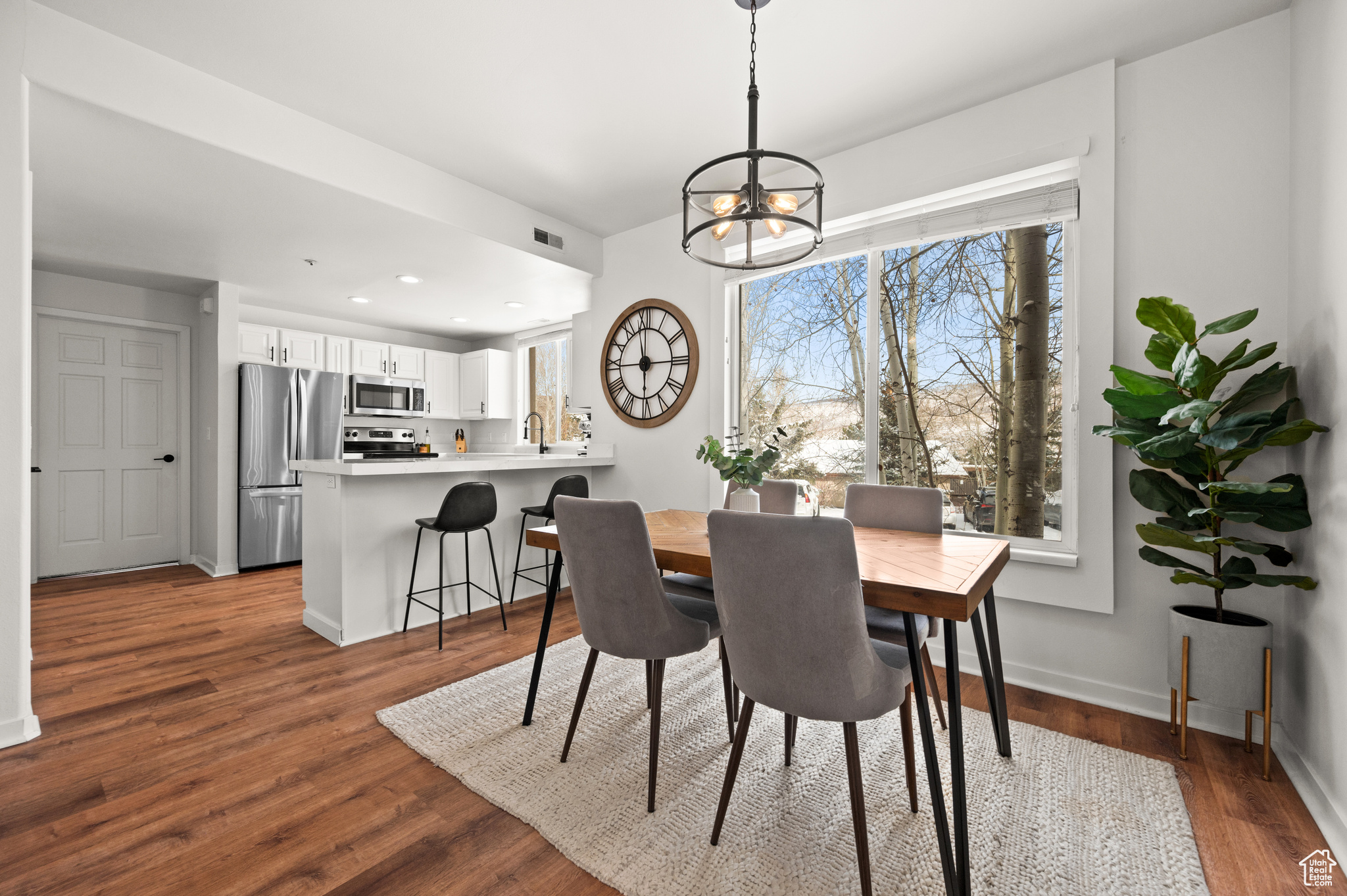 Dining space with a notable chandelier and dark hardwood / wood-style flooring