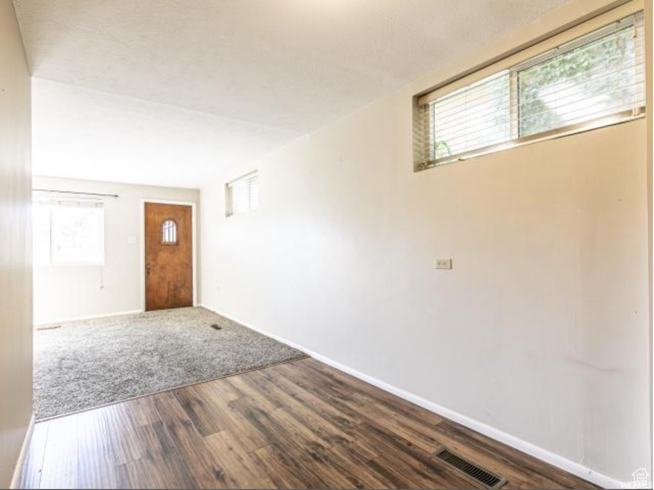 Foyer entrance with a wealth of natural light and dark wood-type flooring