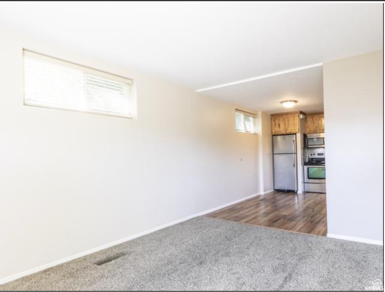 Unfurnished room featuring dark colored carpet