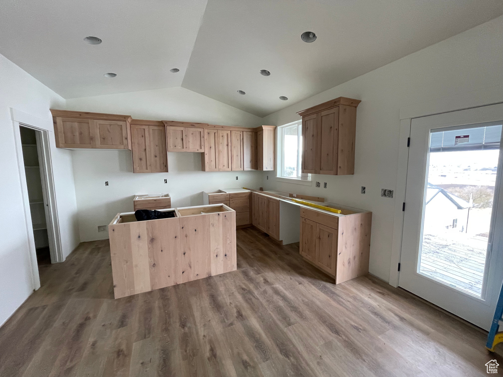 Kitchen with a kitchen island, light hardwood / wood-style flooring, a wealth of natural light, and vaulted ceiling