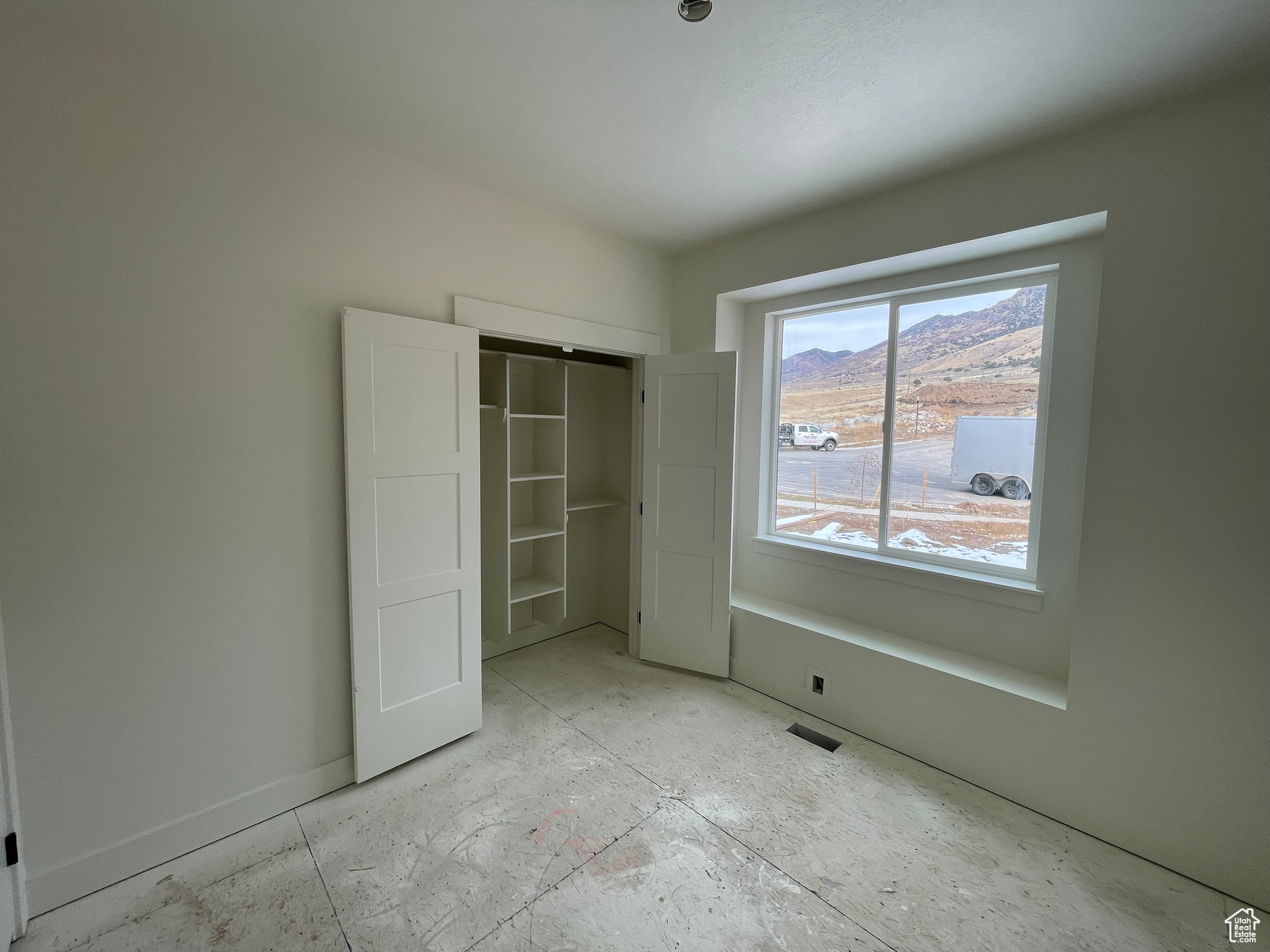 Unfurnished bedroom featuring a mountain view and a closet