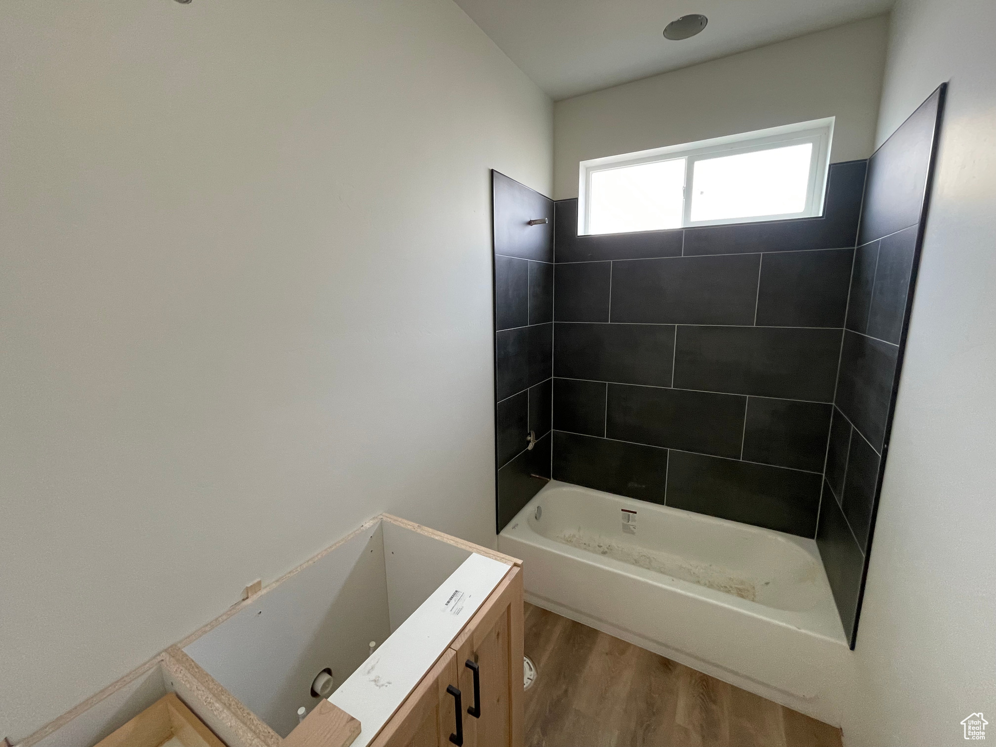 Bathroom featuring hardwood / wood-style floors and tiled shower / bath combo